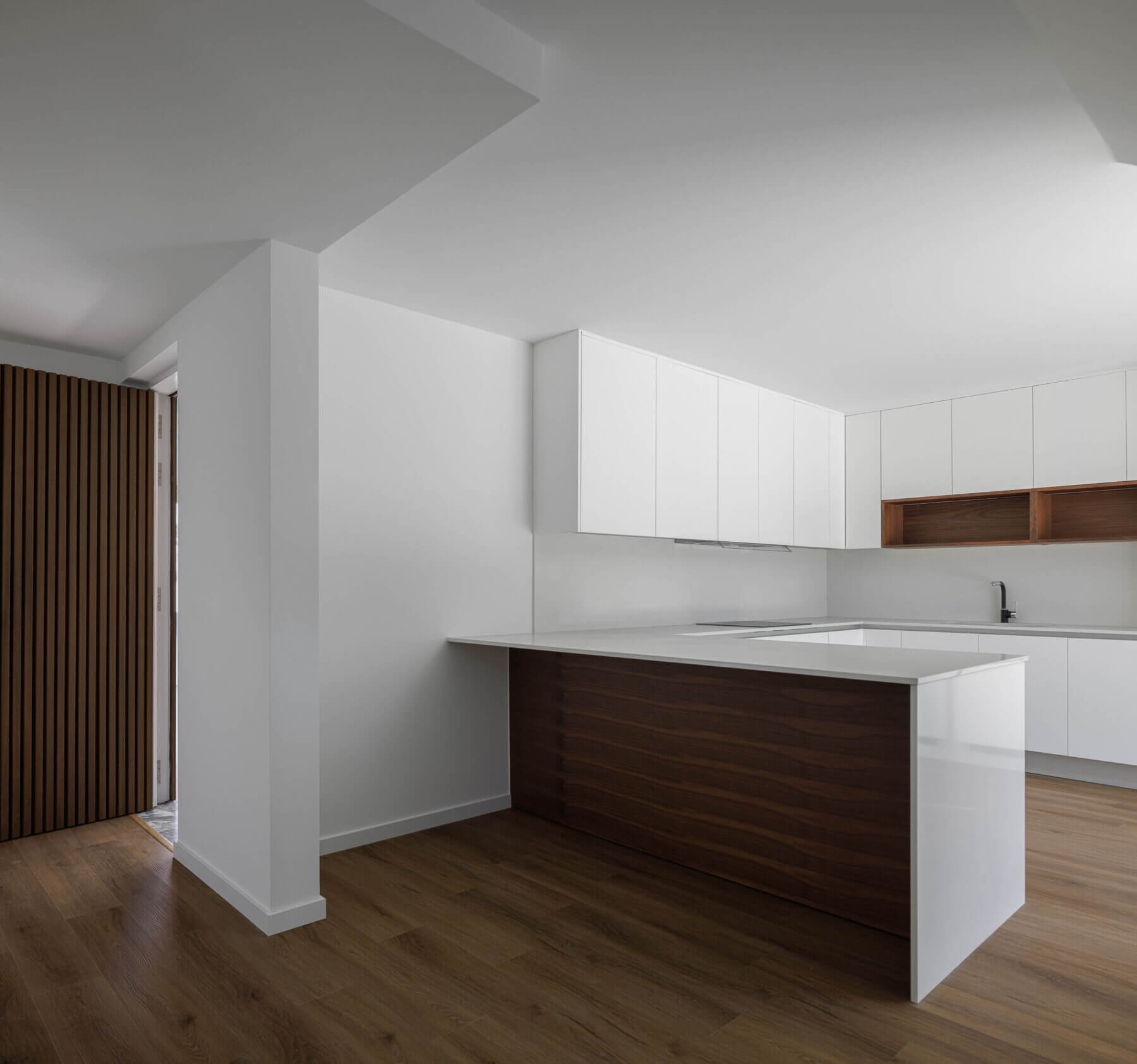 Cozinha: Interior minimalista com armários brancos, ilha central em madeira e pavimento em madeira clara. — Casas BD arquitetura Esquissos Arquitectura em Sintra
