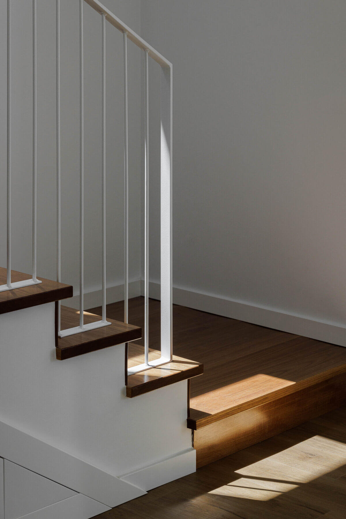 Escadas: Degraus em madeira com estrutura e guarda-corpo brancos, iluminação natural. — Casas BD arquitetura Esquissos Arquitectura em Sintra