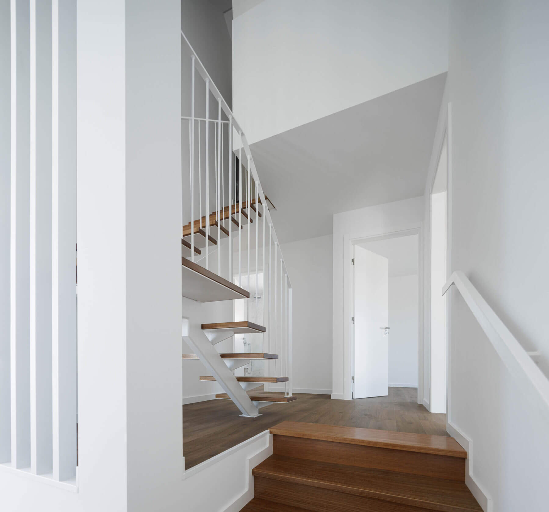 Escadas: Vista do patamar das escadas com guarda-corpo branco e pavimento em madeira. — Casas BD arquitetura Esquissos Arquitectura em Sintra