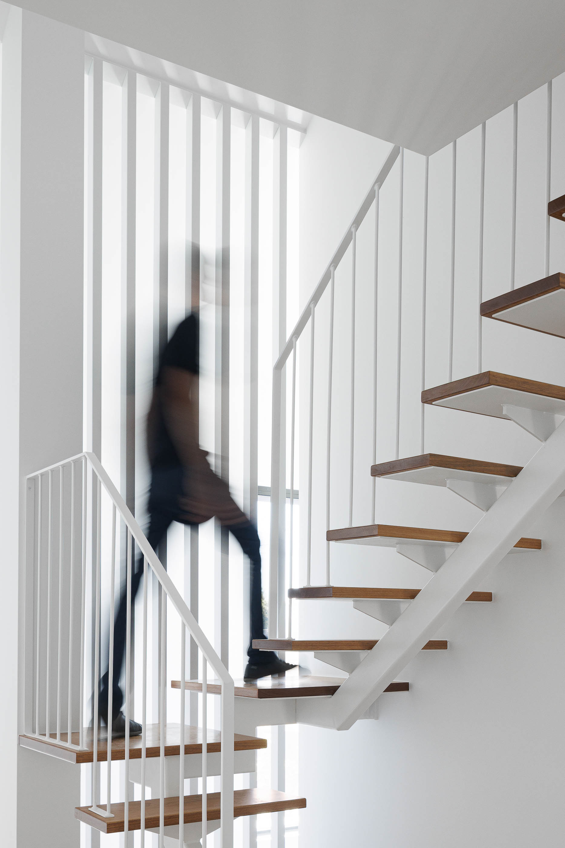 Escadas: Detalhe das escadas de madeira com estrutura e guarda-corpo brancos. — Casas BD arquitetura Esquissos Arquitectura em Sintra