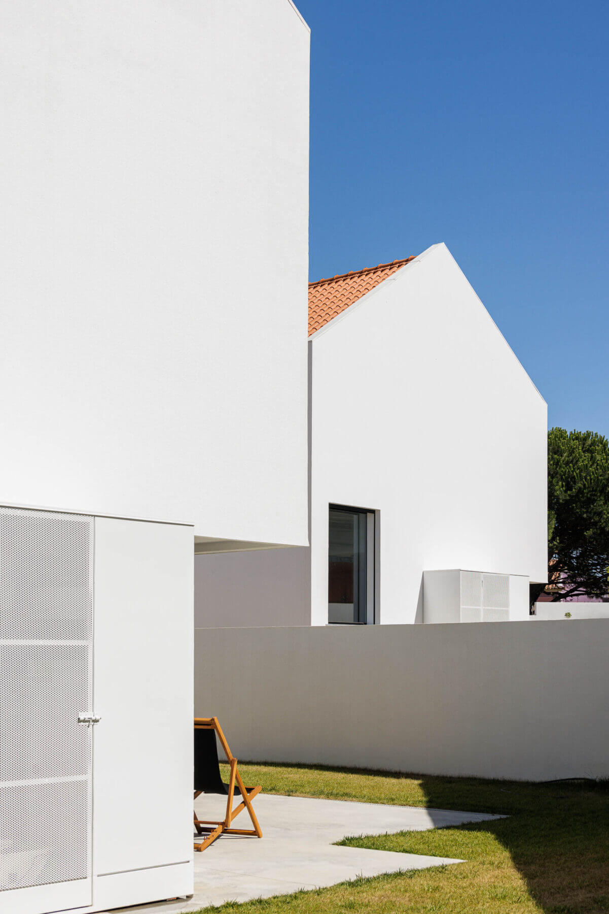 Fachada: Moradia com varanda em betão aparente iluminada ao entardecer. — Casas BD arquitetura Esquissos Arquitectura em Sintra