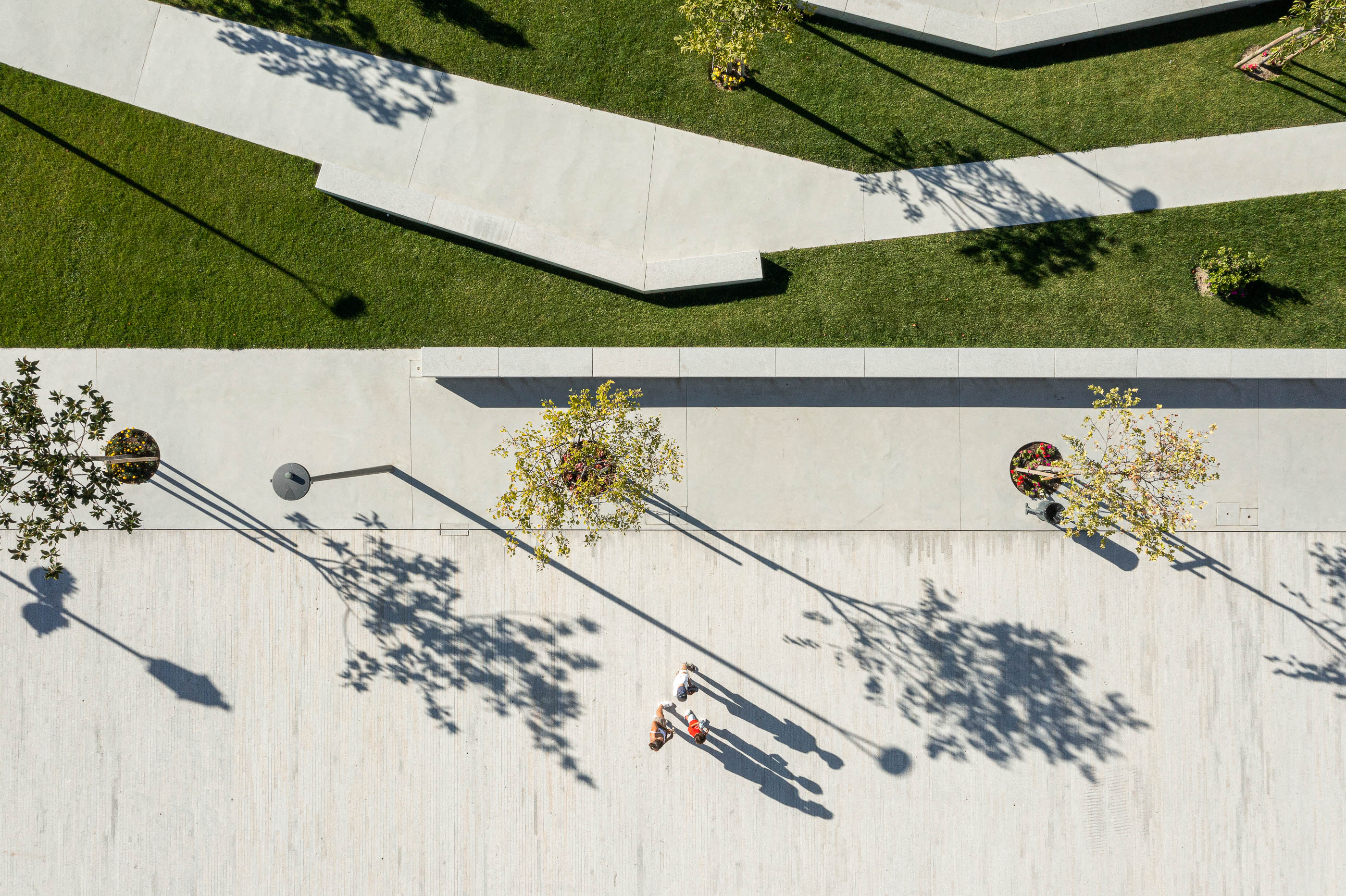 Praça: Vista aérea do relvado com caminhos em granito, árvores e candeeiros. — Requalificação da Praça do Município de Ribeira de Pena arquitetura AXR - Arquitetura e Design em Vila Real