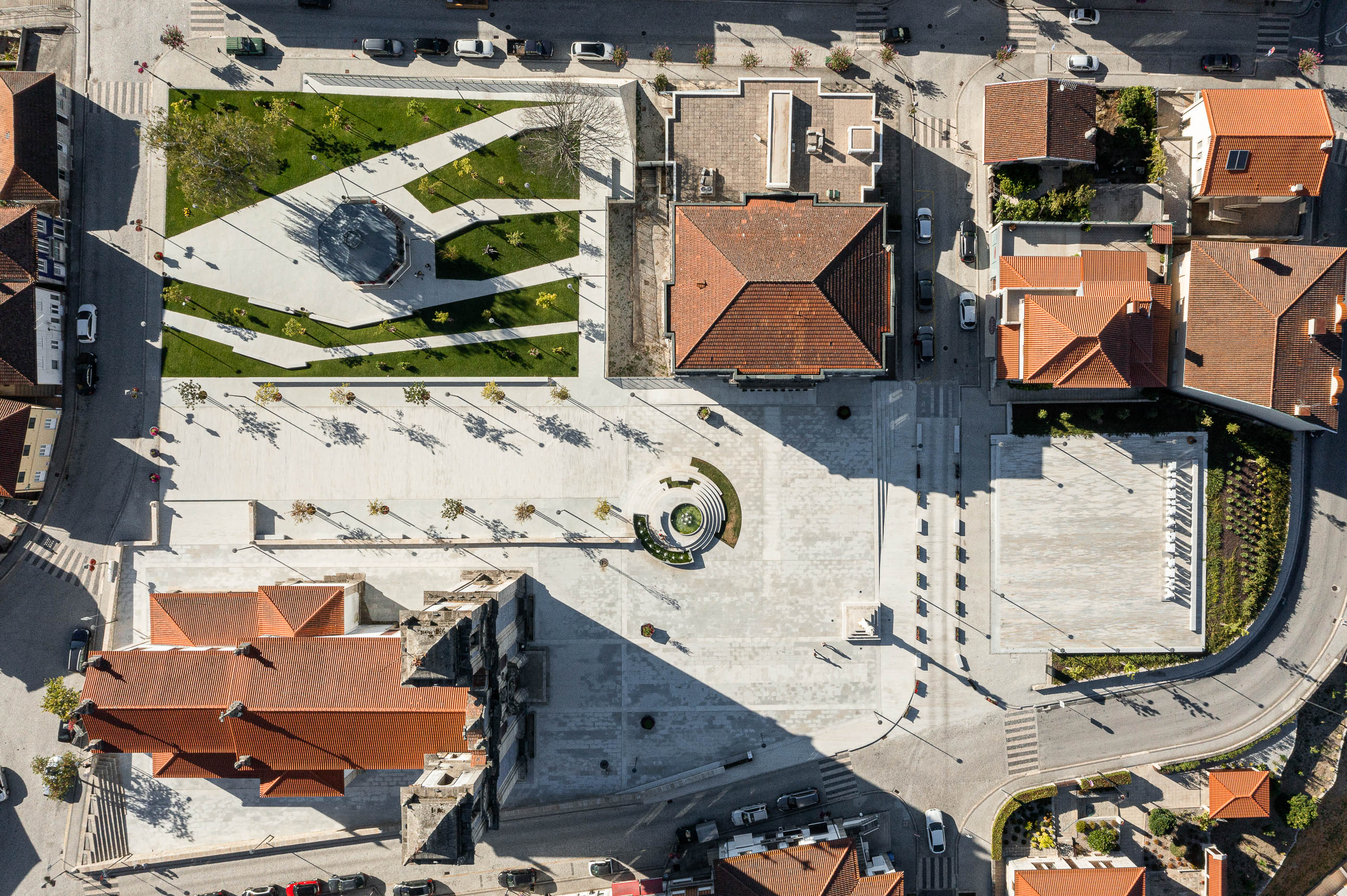 Praça: Vista aérea da vila com a praça central, igreja e edifícios com telhados de cor laranja. — Requalificação da Praça do Município de Ribeira de Pena arquitetura AXR - Arquitetura e Design em Vila Real