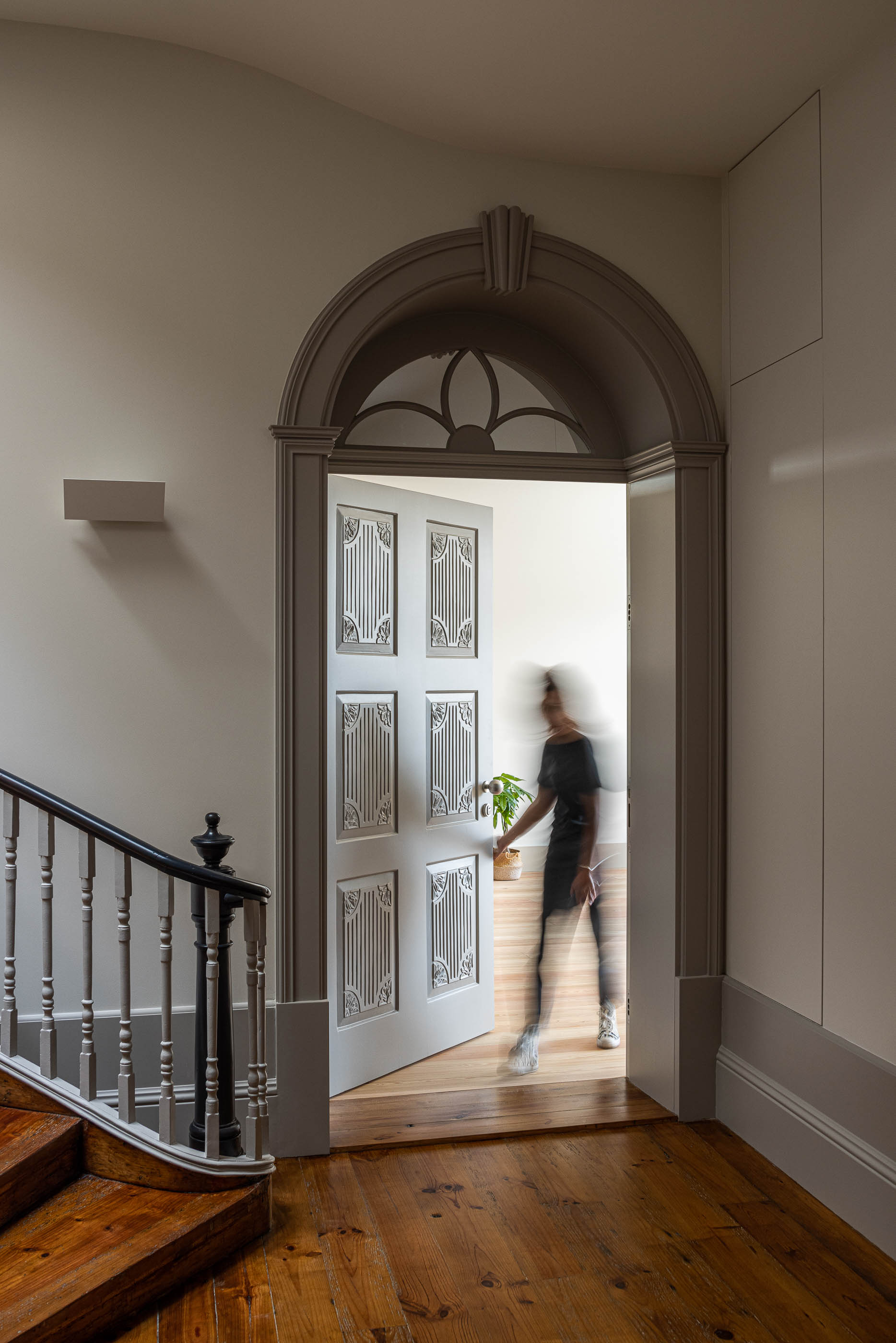 Corredor: Porta de madeira cinza com detalhes ornamentais, pavimento em madeira e rodapé cinza. — Antigo Hotel do Louvre arquitetura Diana Barros Arquitectura em Porto