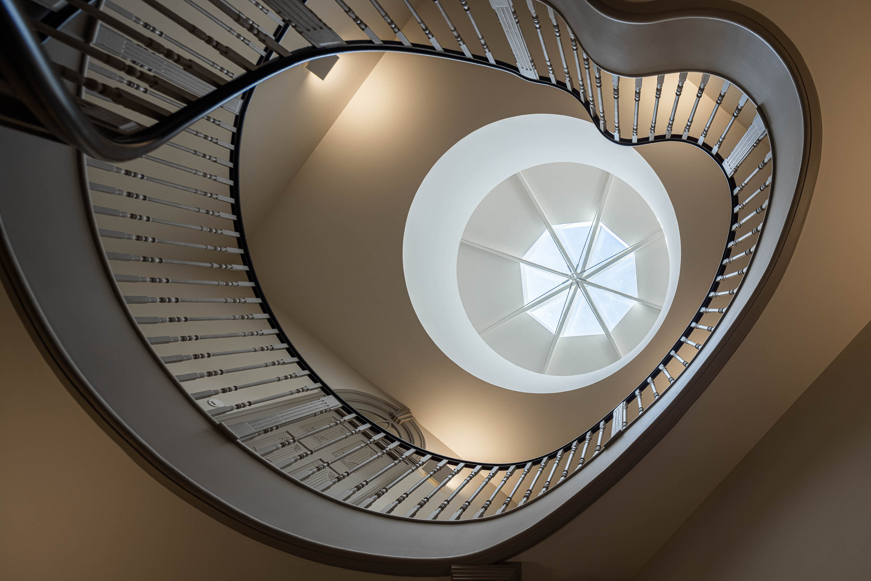 Escadaria: Vista de baixo para cima da claraboia octogonal no topo da escadaria em caracol. — Antigo Hotel do Louvre arquitetura Diana Barros Arquitectura em Porto