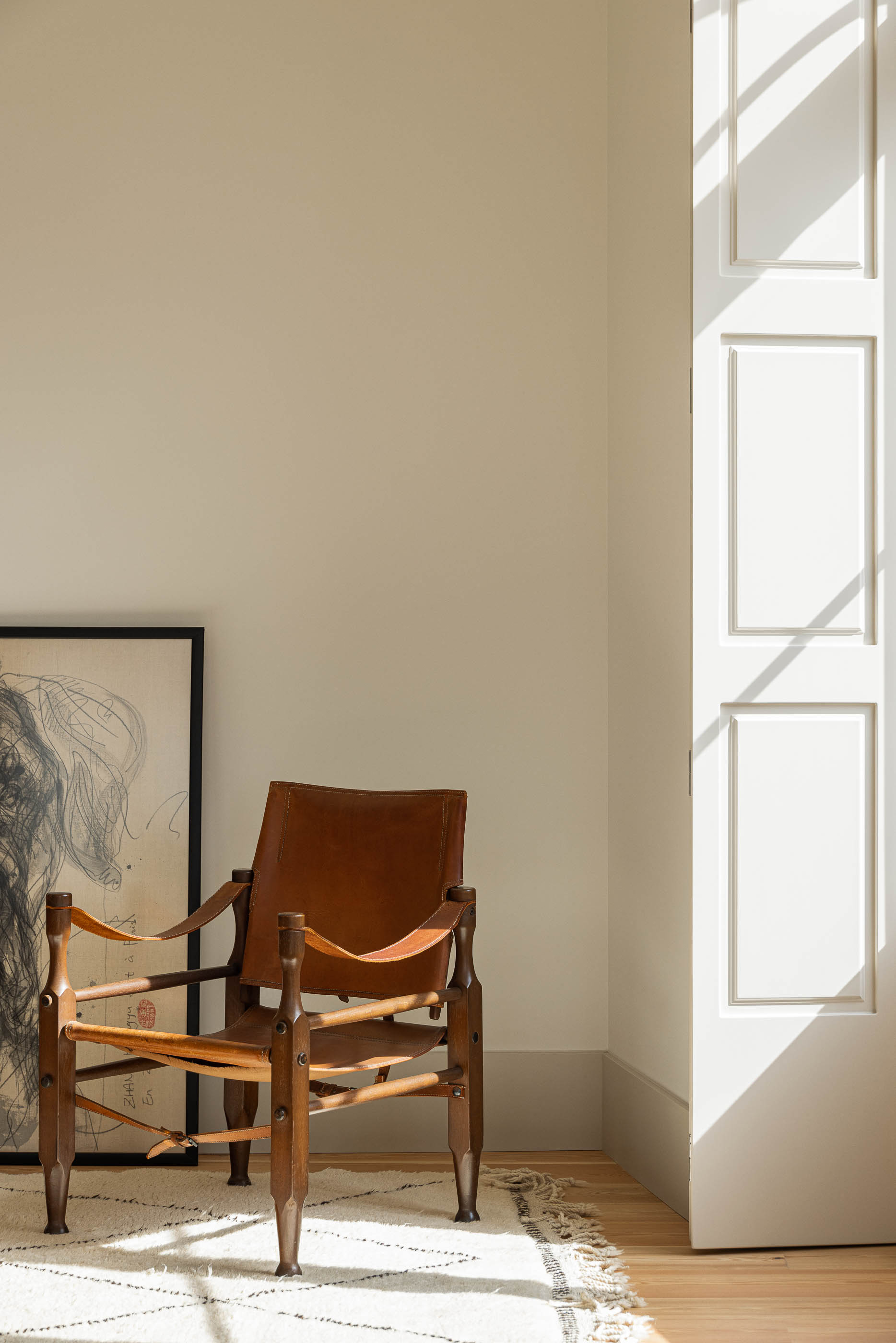 Sala de estar: Cadeira de madeira e pele junto à janela com portadas, alcatifa geométrica. — Antigo Hotel do Louvre arquitetura Diana Barros Arquitectura em Porto