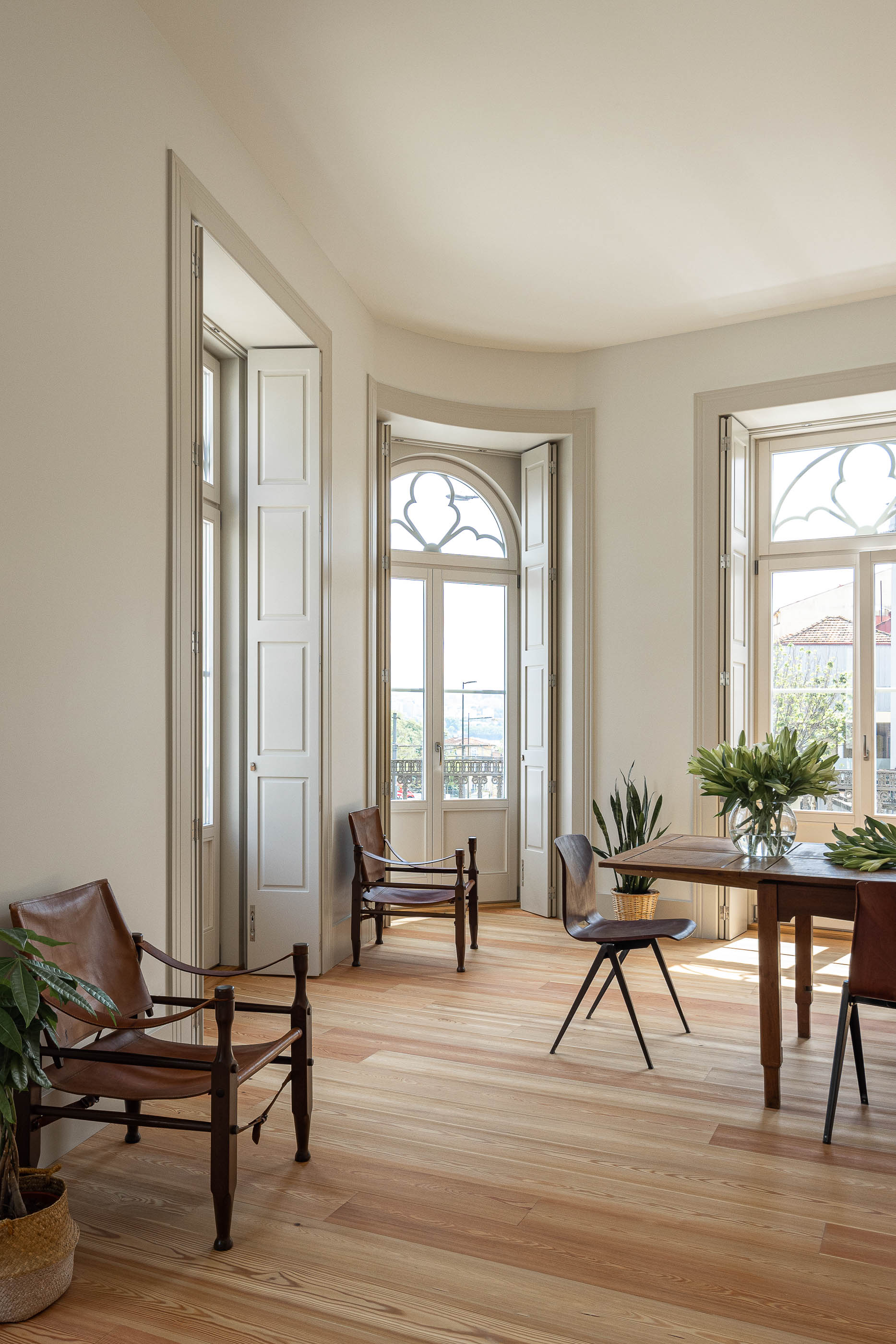 Sala de jantar: Sala de jantar luminosa com janelas em arco e mobiliário vintage. — Antigo Hotel do Louvre arquitetura Diana Barros Arquitectura em Porto