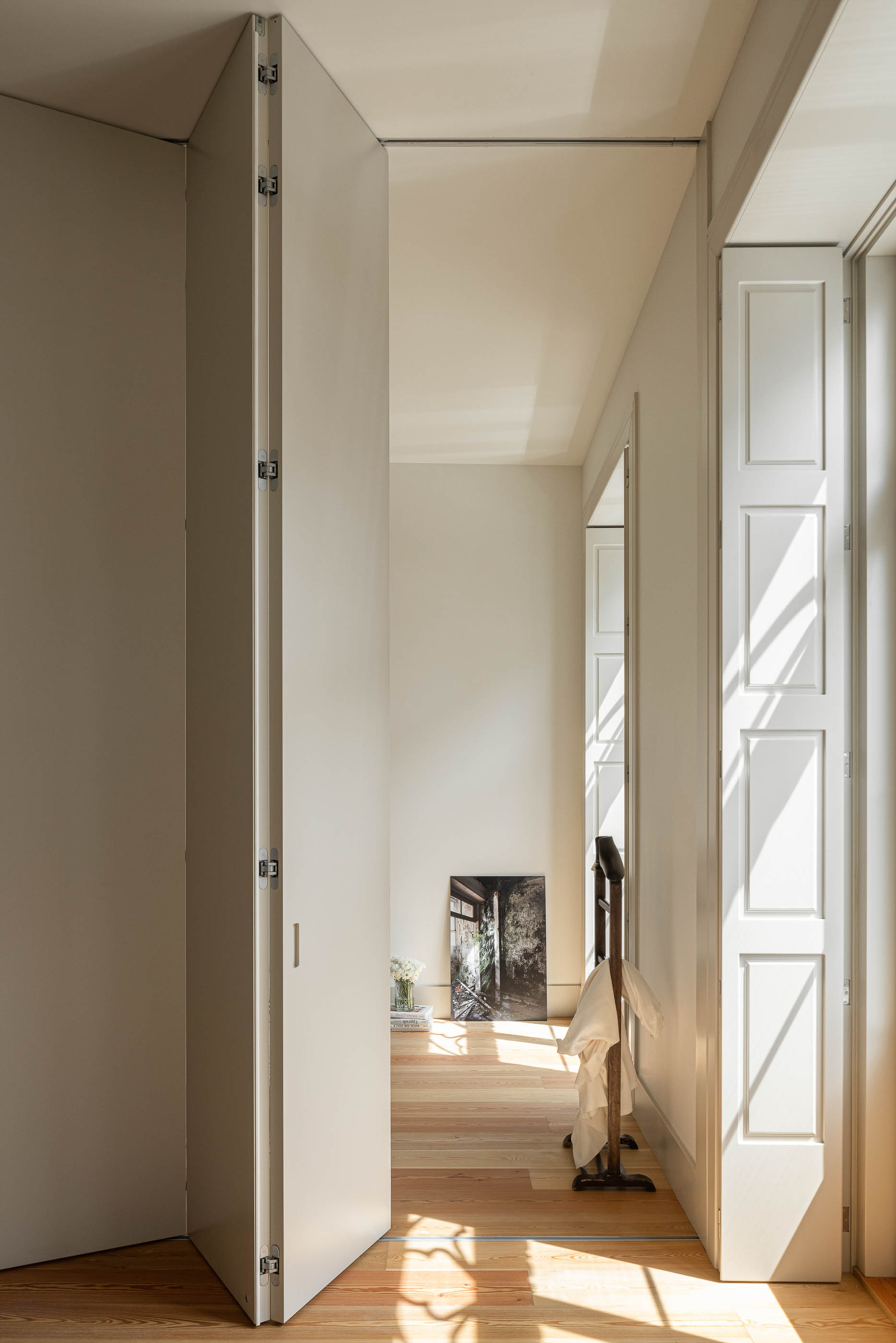 Quarto: Quarto com divisórias de correr, pavimento em madeira e janela com portadas. — Antigo Hotel do Louvre arquitetura Diana Barros Arquitectura em Porto