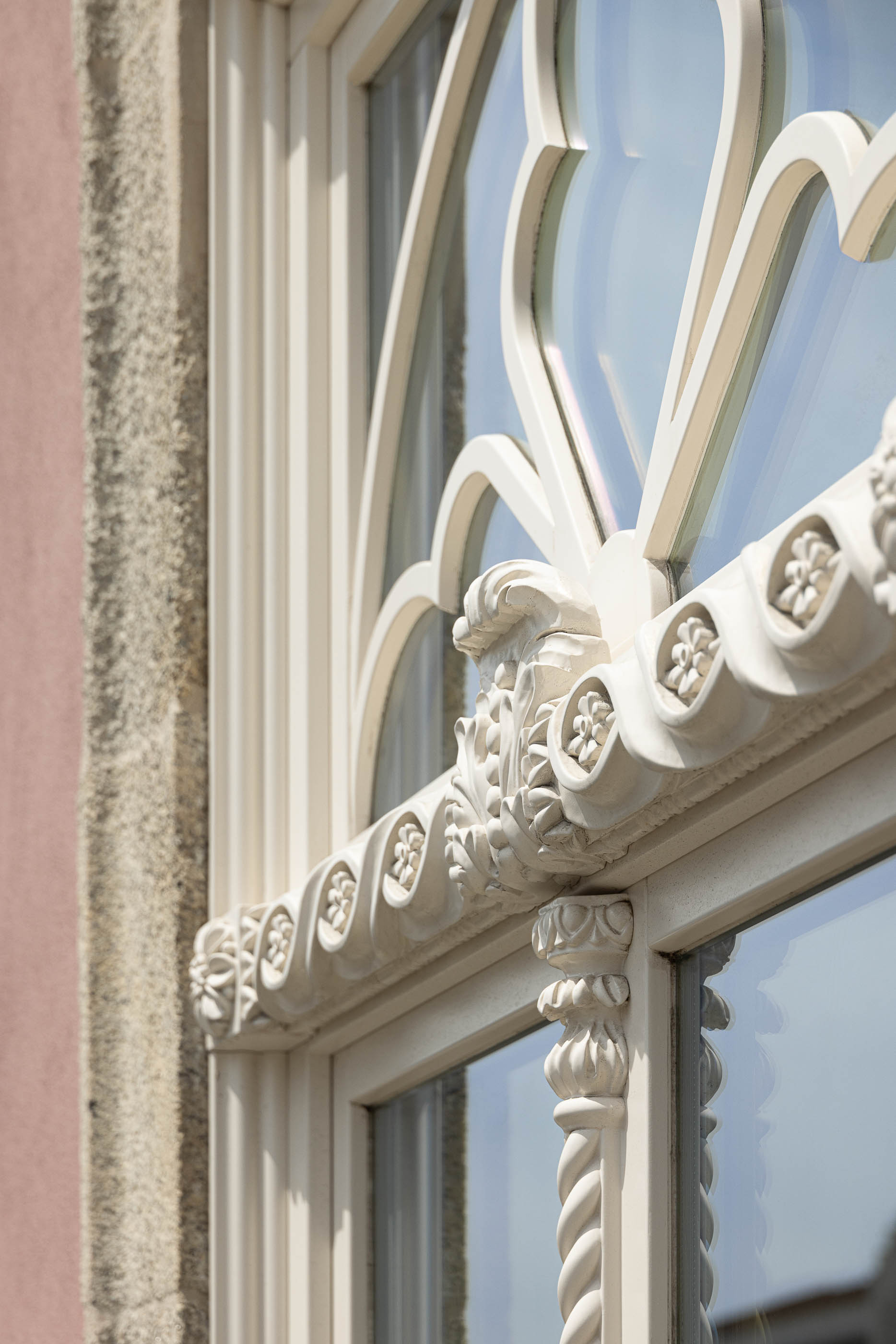 Exterior: Detalhe da janela em arco com decoração floral na fachada do edifício. — Antigo Hotel do Louvre arquitetura Diana Barros Arquitectura em Porto