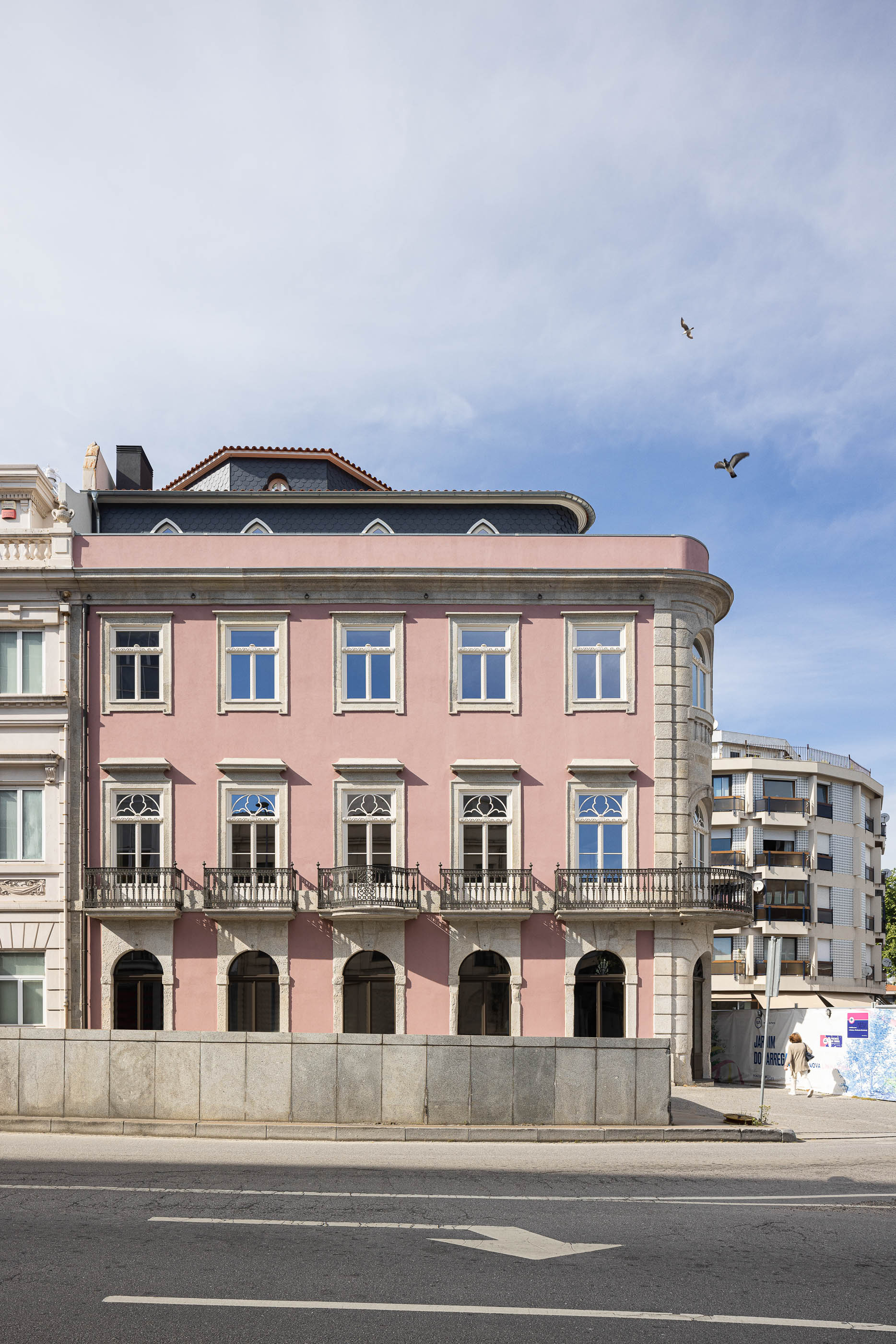 Exterior: Vista geral da fachada do edifício rosa com varandas em ferro forjado. — Antigo Hotel do Louvre arquitetura Diana Barros Arquitectura em Porto