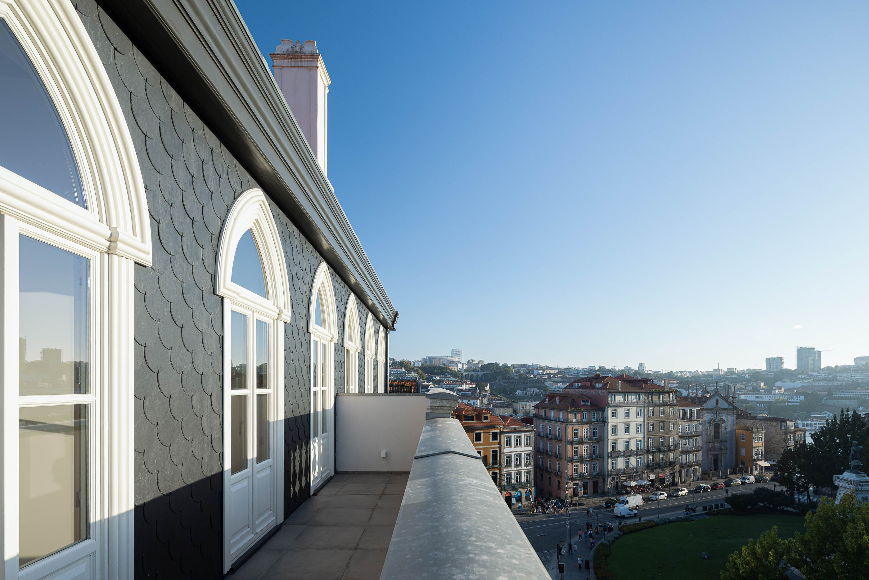 Exterior: Vista panorâmica da cidade a partir do terraço superior do edifício, com telhado em escamas. — Edifício de Mouzinho da Silveira arquitetura Diana Barros Arquitectura em Porto