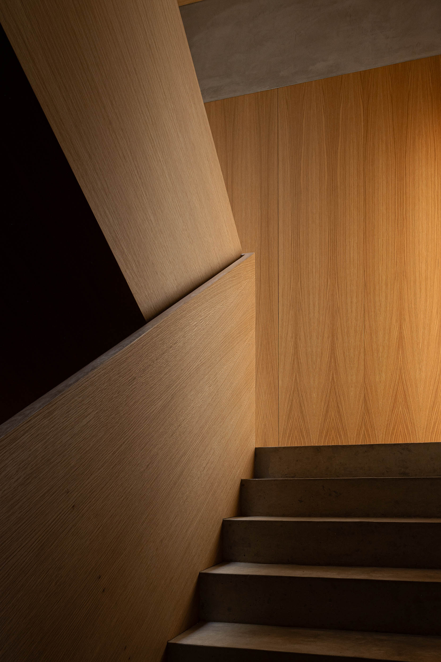 Escadas: Detalhe da escada com degraus em pedra e paredes revestidas a madeira clara. — Edifício de Mouzinho da Silveira arquitetura Diana Barros Arquitectura em Porto