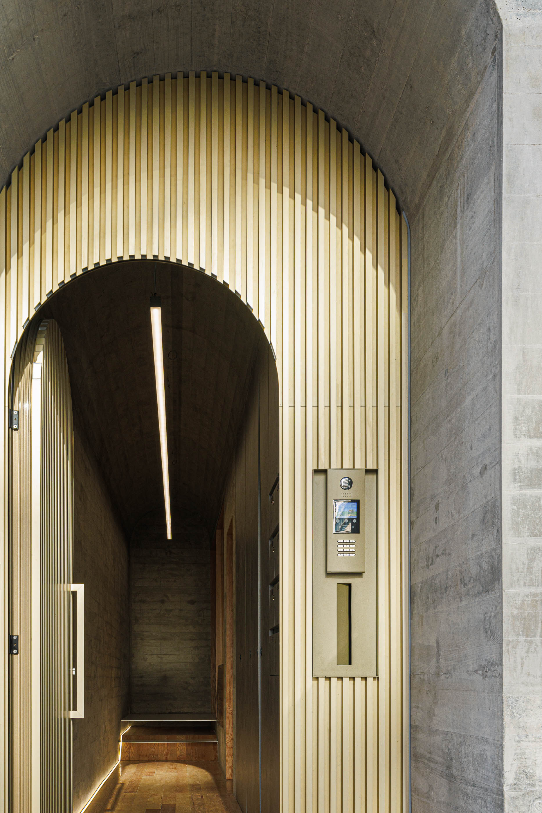 Entrada do edifício com porta aberta, iluminação linear e videoporteiro embutido. — Boavista 339 arquitetura Paulo Merlini Architects em Porto
