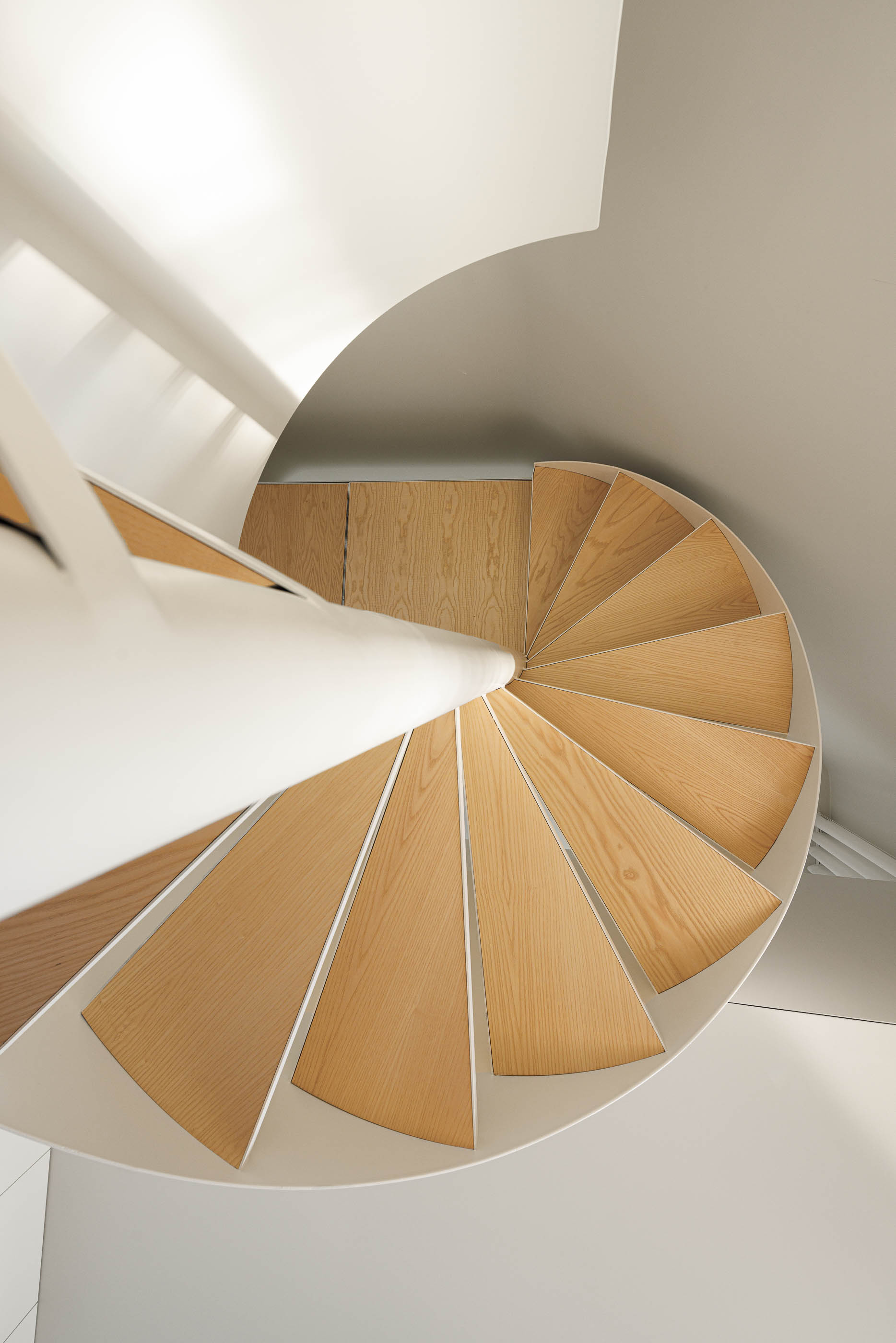 Vista de cima da escada em caracol branca com degraus em madeira clara. — Boavista 339 arquitetura Paulo Merlini Architects em Porto