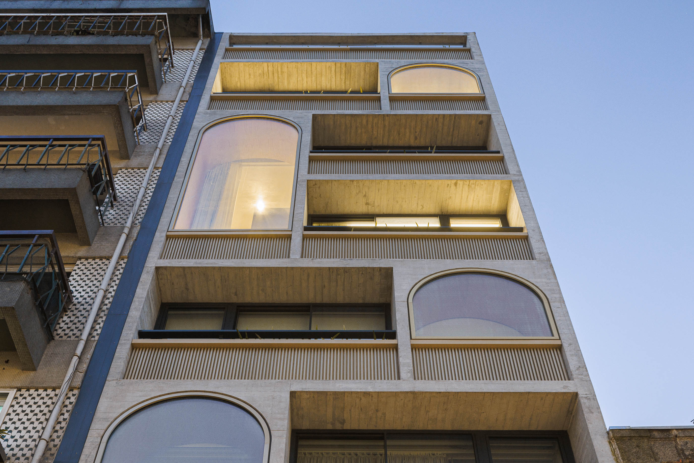 Vista vertical da fachada do edifício "Boavista 339" com janelas em arco e varandas. — Boavista 339 arquitetura Paulo Merlini Architects em Porto