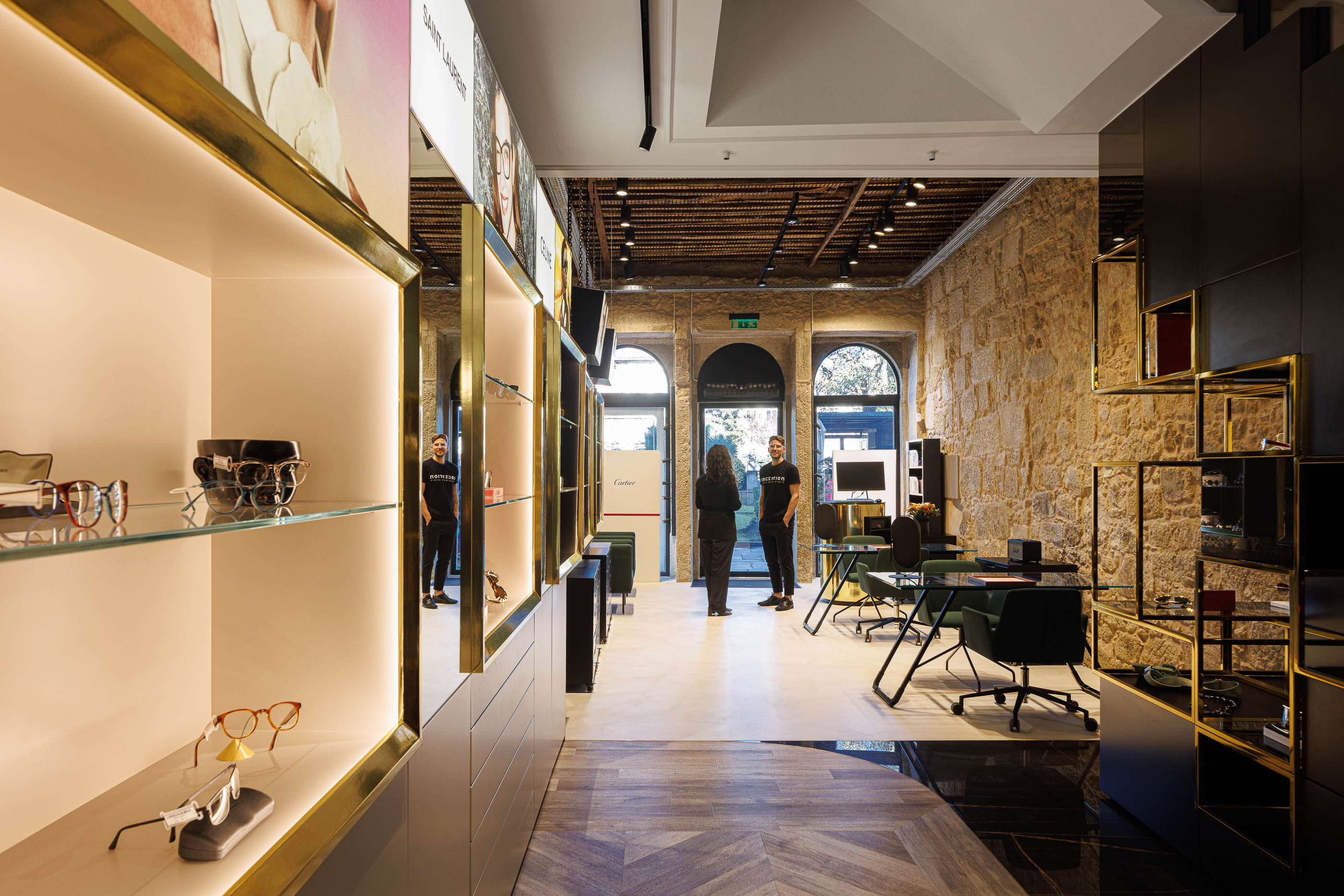 Loja: Perspectiva da loja com expositores, zona de atendimento e pavimento em madeira e mármore. — Jorge Oculista arquitetura Inception Architects Studio em Braga