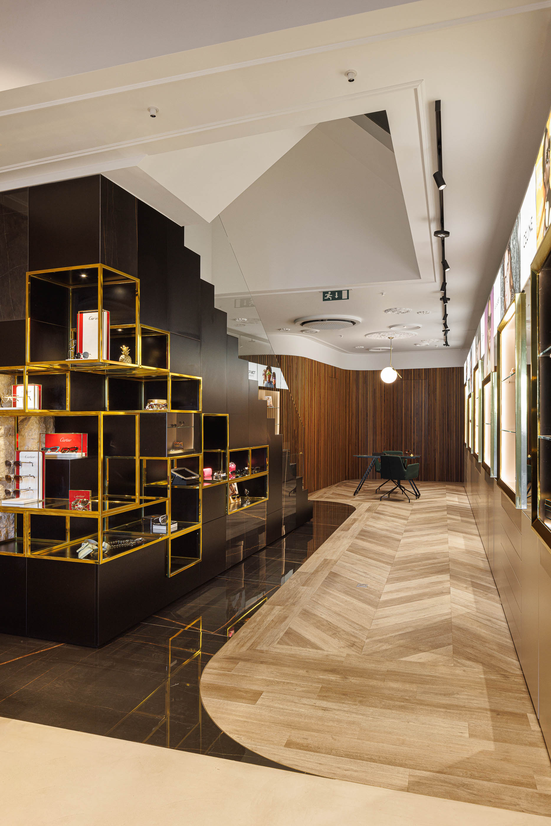 Escadas: Escadas com prateleiras decorativas, pavimento em espinha de peixe e zona de atendimento ao fundo. — Jorge Oculista arquitetura Inception Architects Studio em Braga