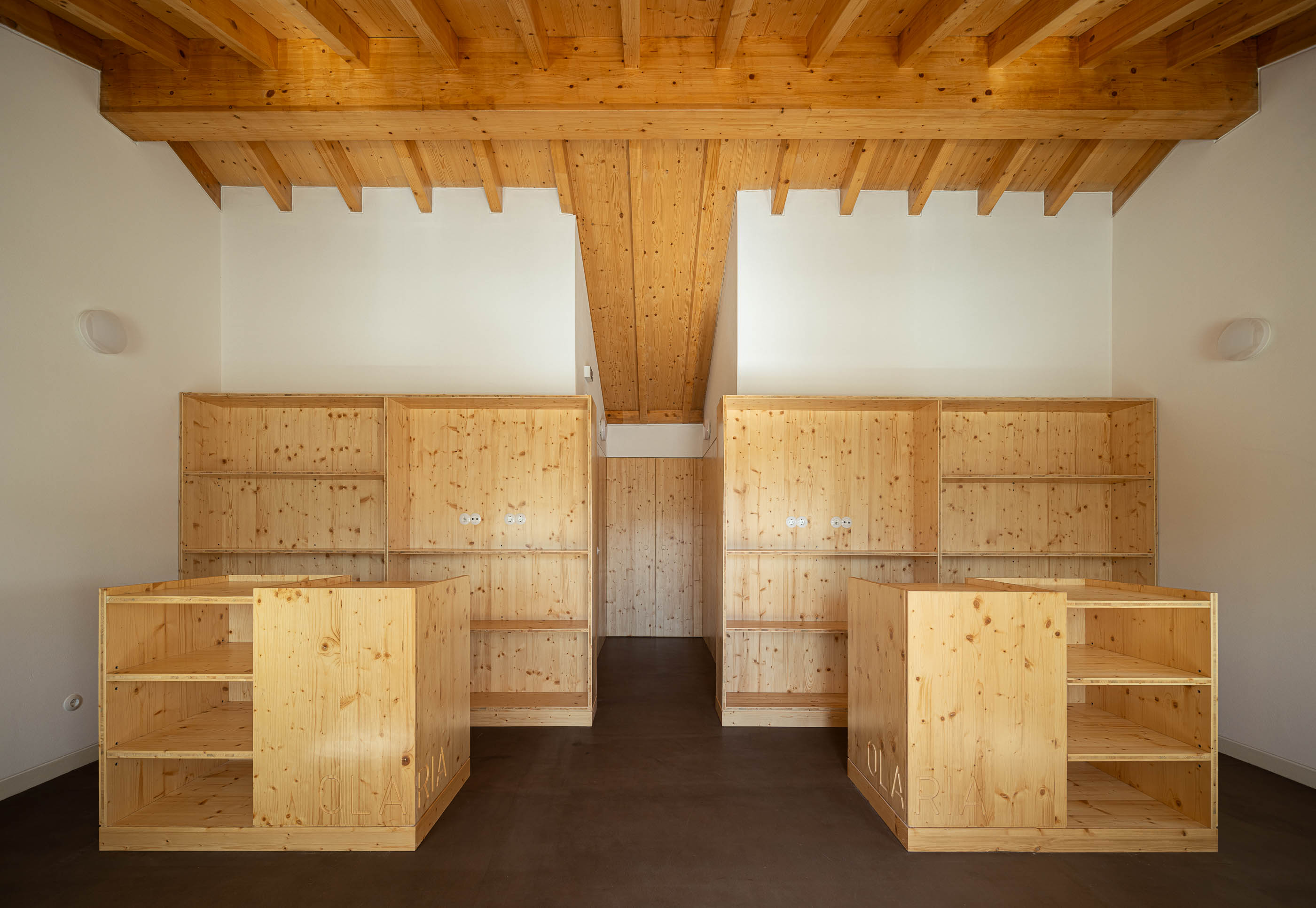 Armazém: Sala com teto de madeira, armários de madeira e pavimento castanho. — Olaria Municipal arquitetura ARDE Arquitetura+Design em Odemira