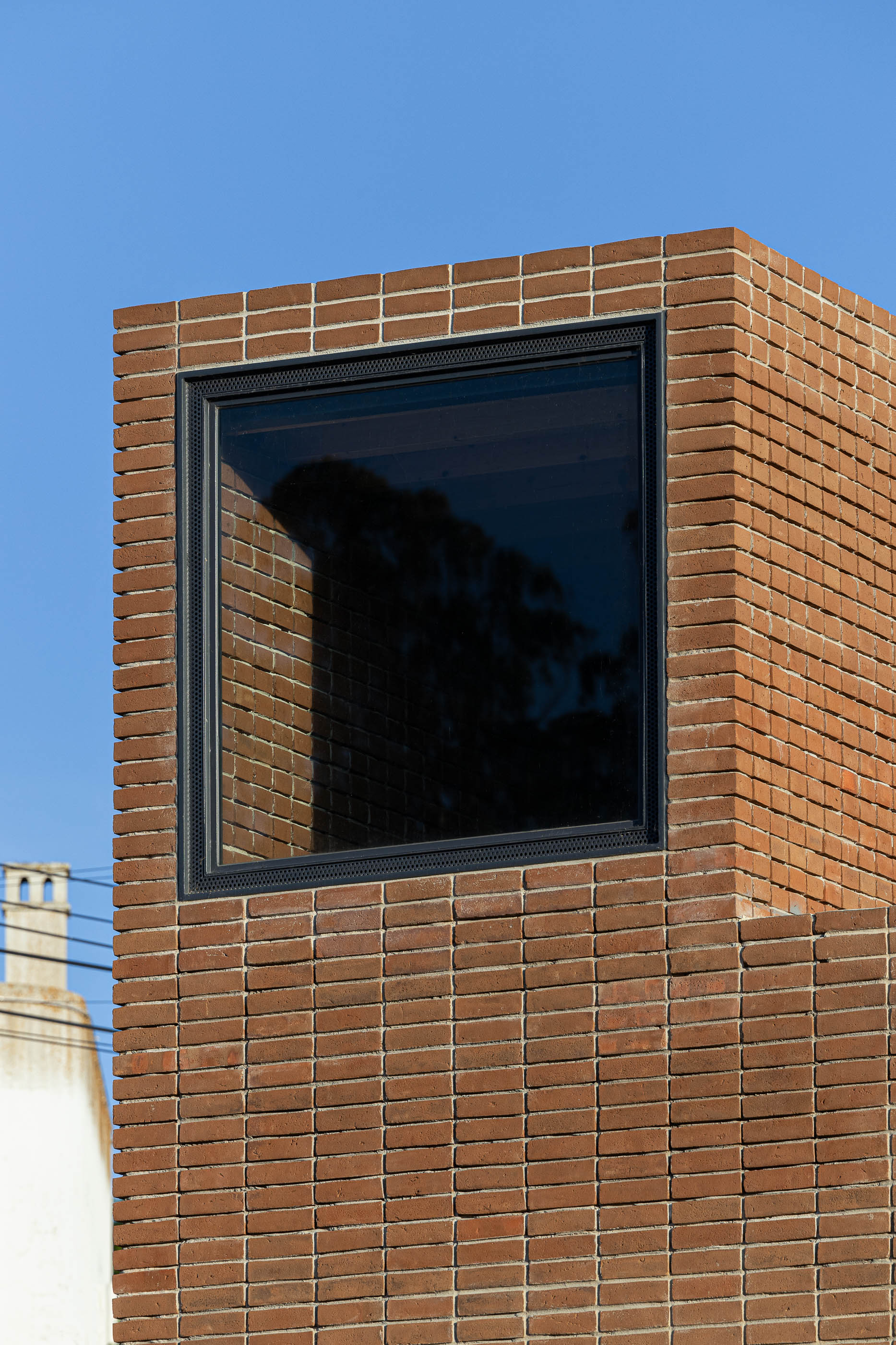 Fachada: Detalhe da janela na torre de tijolo. — Olaria Municipal arquitetura ARDE Arquitetura+Design em Odemira