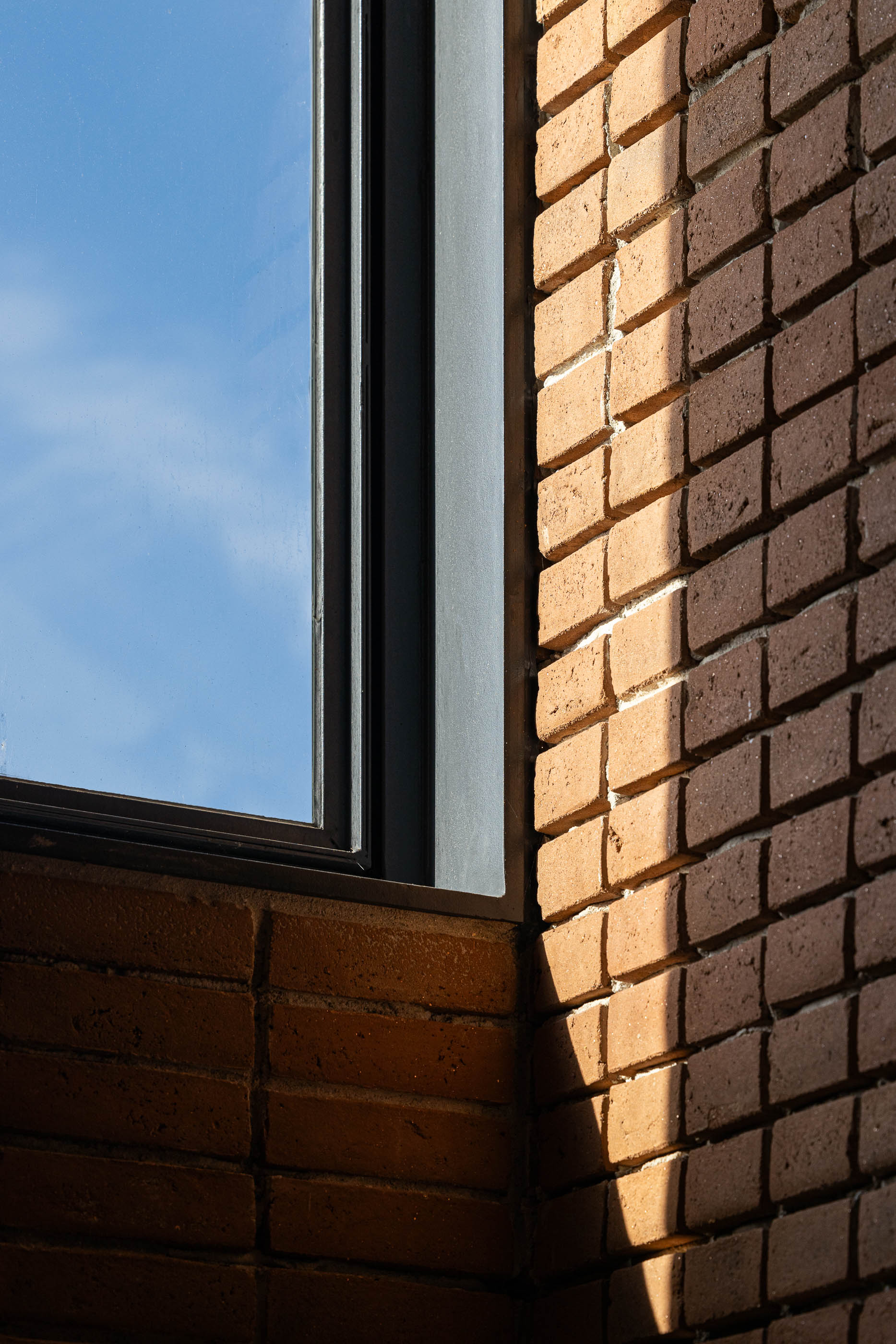 Fachada: Detalhe da janela na torre de tijolo, mostrando a textura do tijolo. — Olaria Municipal arquitetura ARDE Arquitetura+Design em Odemira