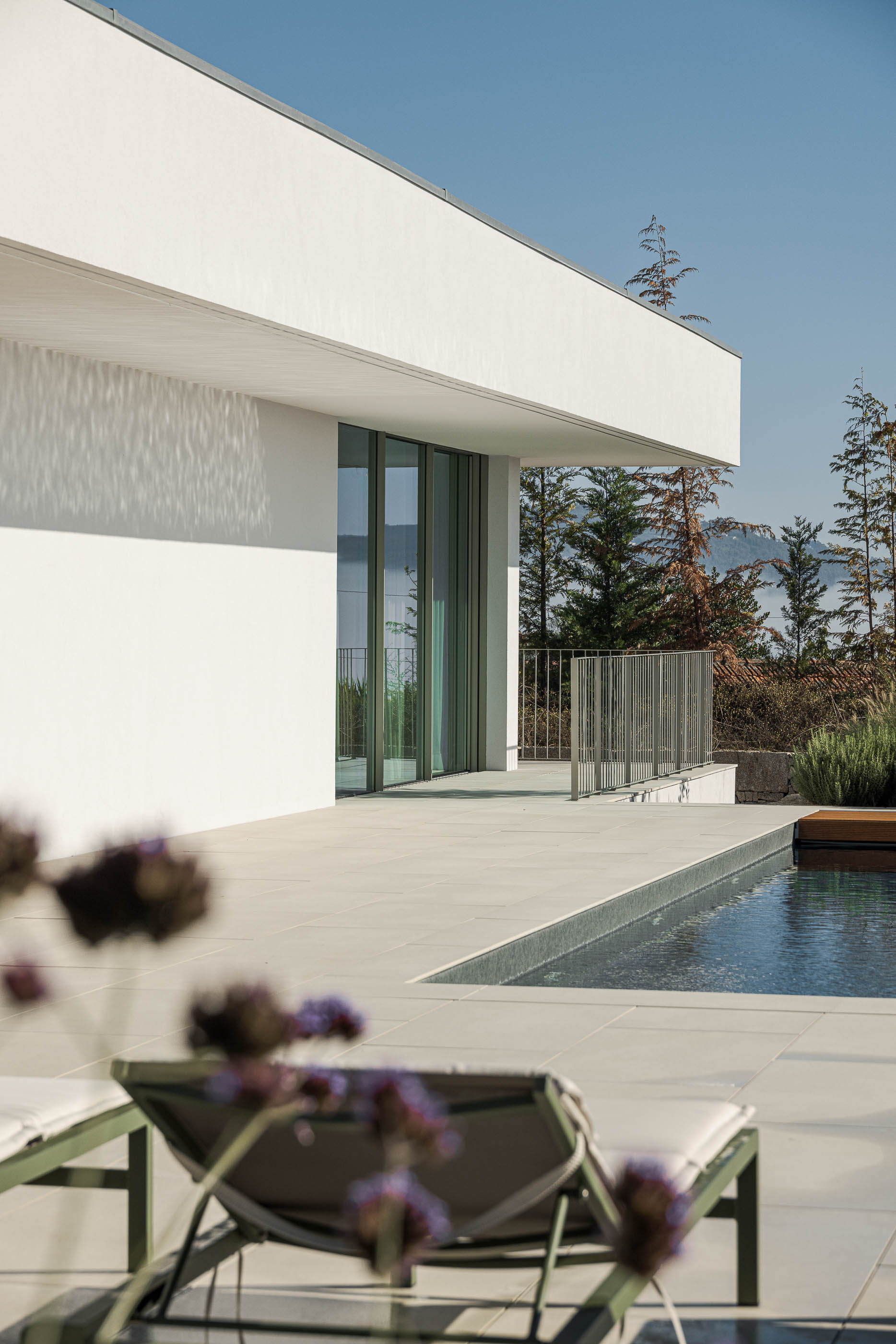 Exterior da moradia com piscina, pavimento cerâmico e guarda-corpos metálicos. — Habitação Áurea arquitetura stu.dere em Amarante