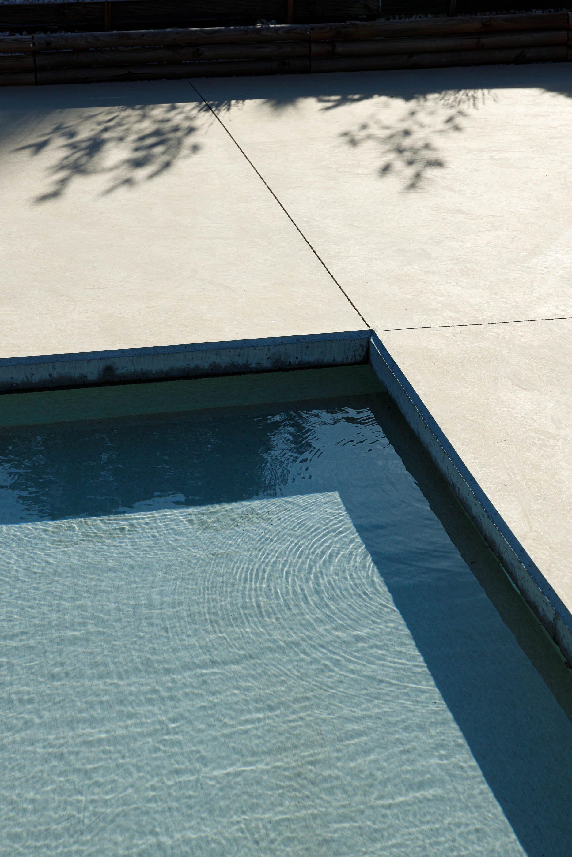 Exterior: Detalhe da piscina com água cristalina e borda em betão. — Casa em Mundão arquitetura Um para Um, arquitectura e engenharia em Viseu