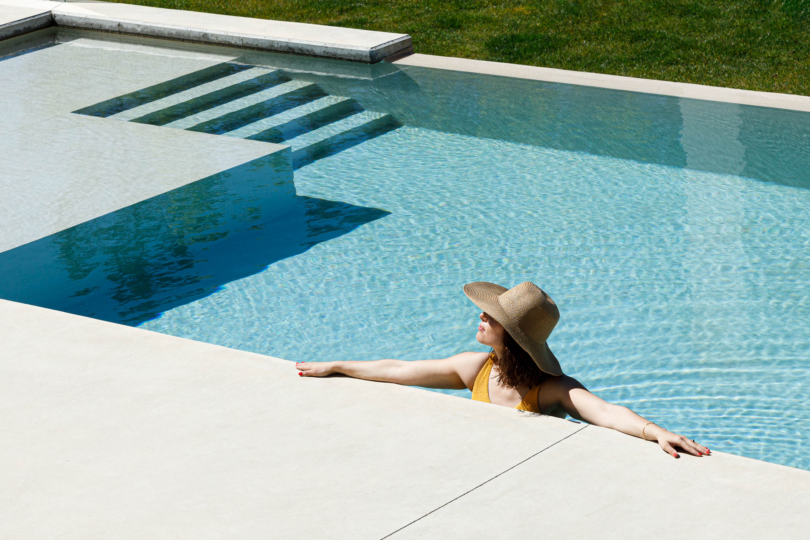 Exterior: Piscina com mulher a relaxar na água e escadas submersas. — Casa em Mundão arquitetura Um para Um, arquitectura e engenharia em Viseu