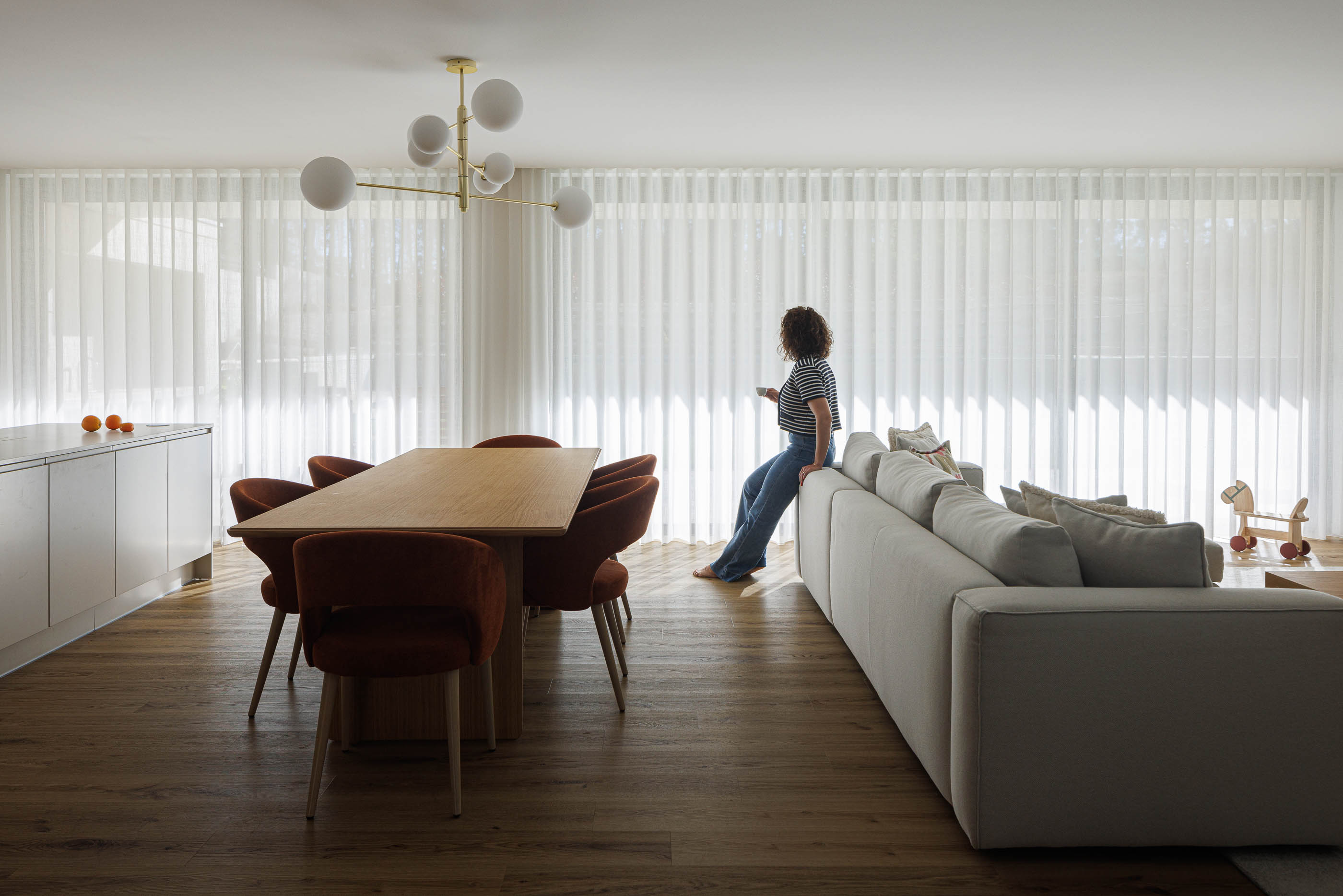 Sala de estar/Jantar: Espaço amplo com mesa de jantar, cadeiras, sofá e candeeiro moderno. — Casa em Mundão arquitetura Um para Um, arquitectura e engenharia em Viseu
