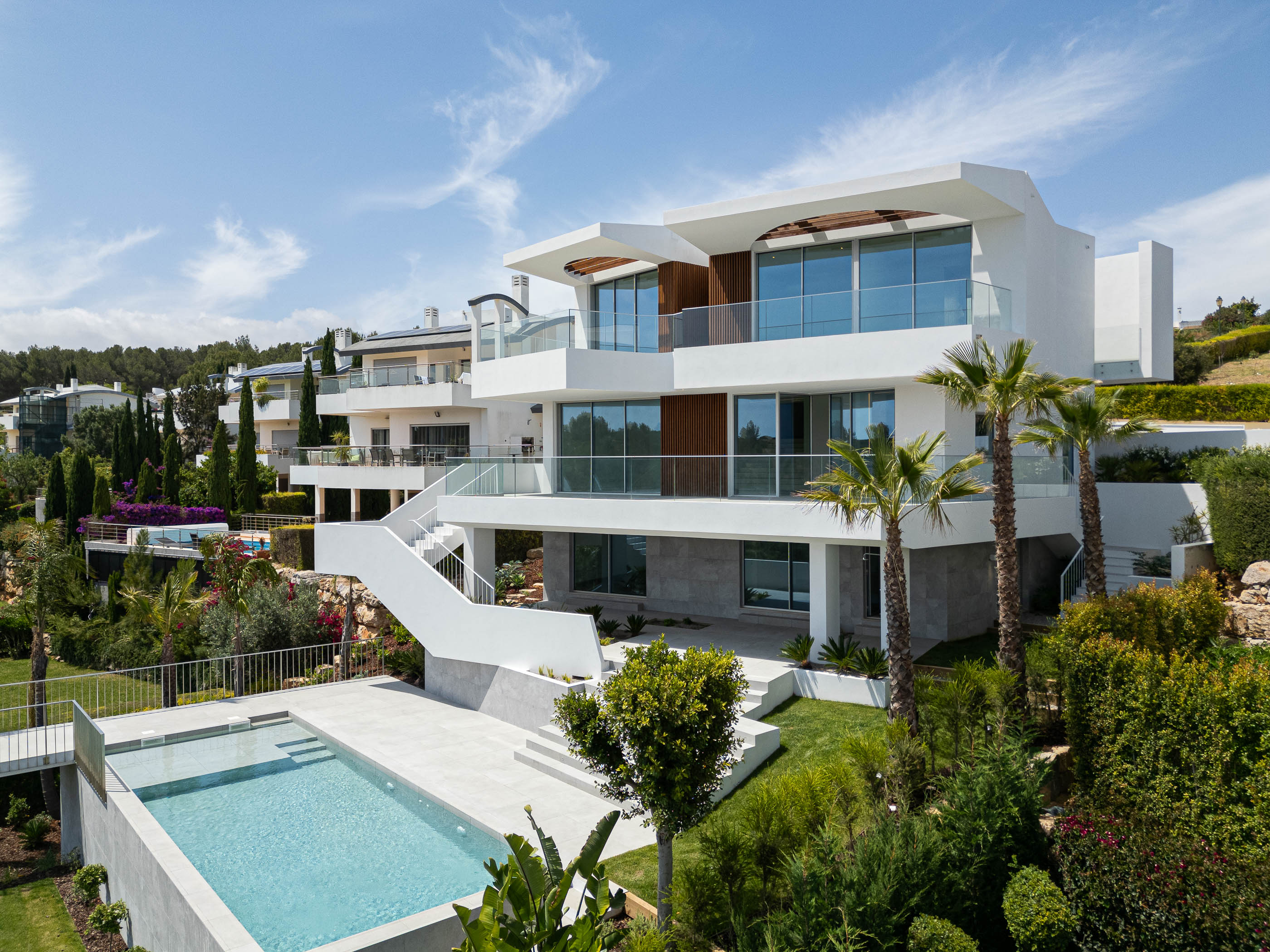 Exterior: Fachada da moradia com piscina, escadas e vegetação. — Villa Fortaleza arquitetura Vieira de Moura Architects em Algarve