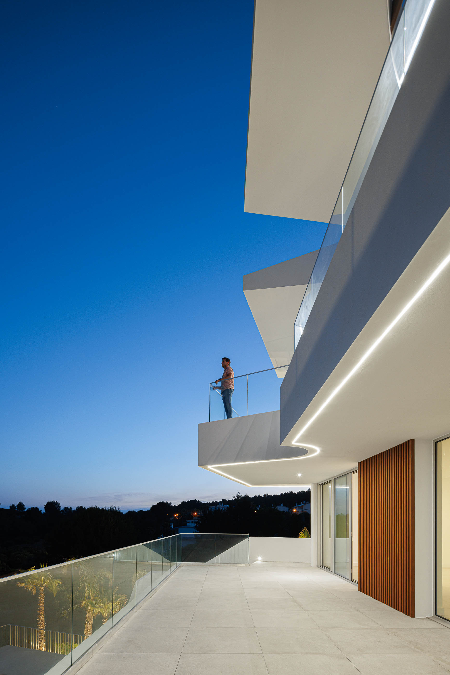 Varanda: Iluminação linear, vista noturna para a paisagem. — Villa Fortaleza arquitetura Vieira de Moura Architects em Algarve