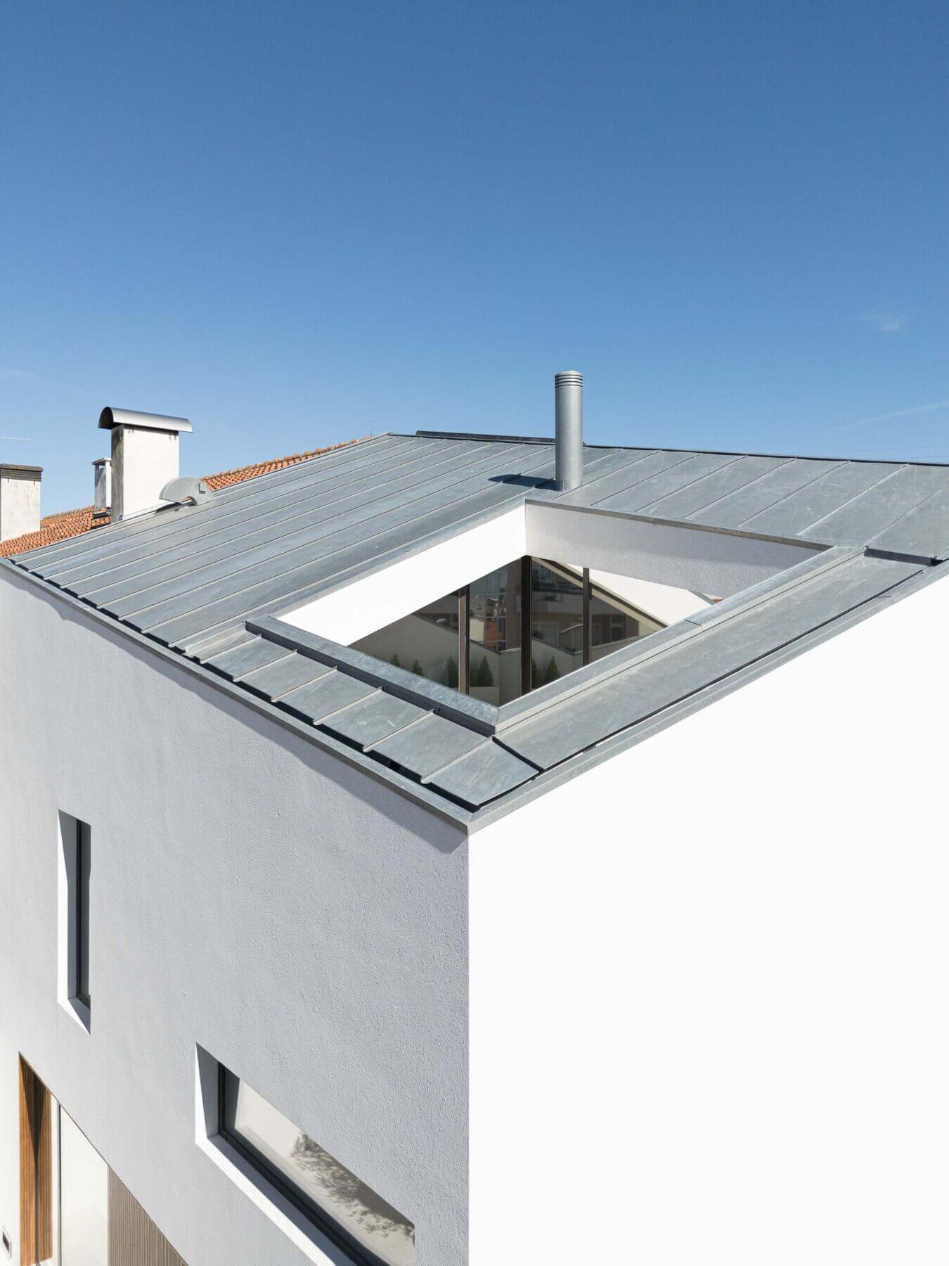 Exterior: Vista do telhado da casa com claraboia e revestimento metálico, com design moderno. — Casa Forca-Vouga arquitetura RVDM - Ricardo Vieira de Melo, arquitectos em Aveiro