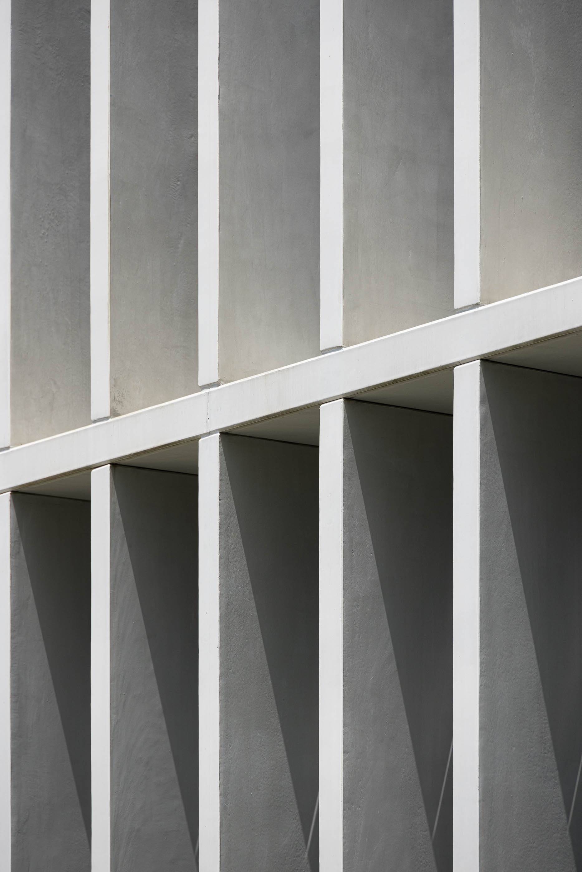 Fachada: Detalhe das colunas de betão branco que formam a grelha da fachada. — BW II – Edifício Industrial em Viana do Castelo arquitetura Multiprojectus em Viana do Castelo