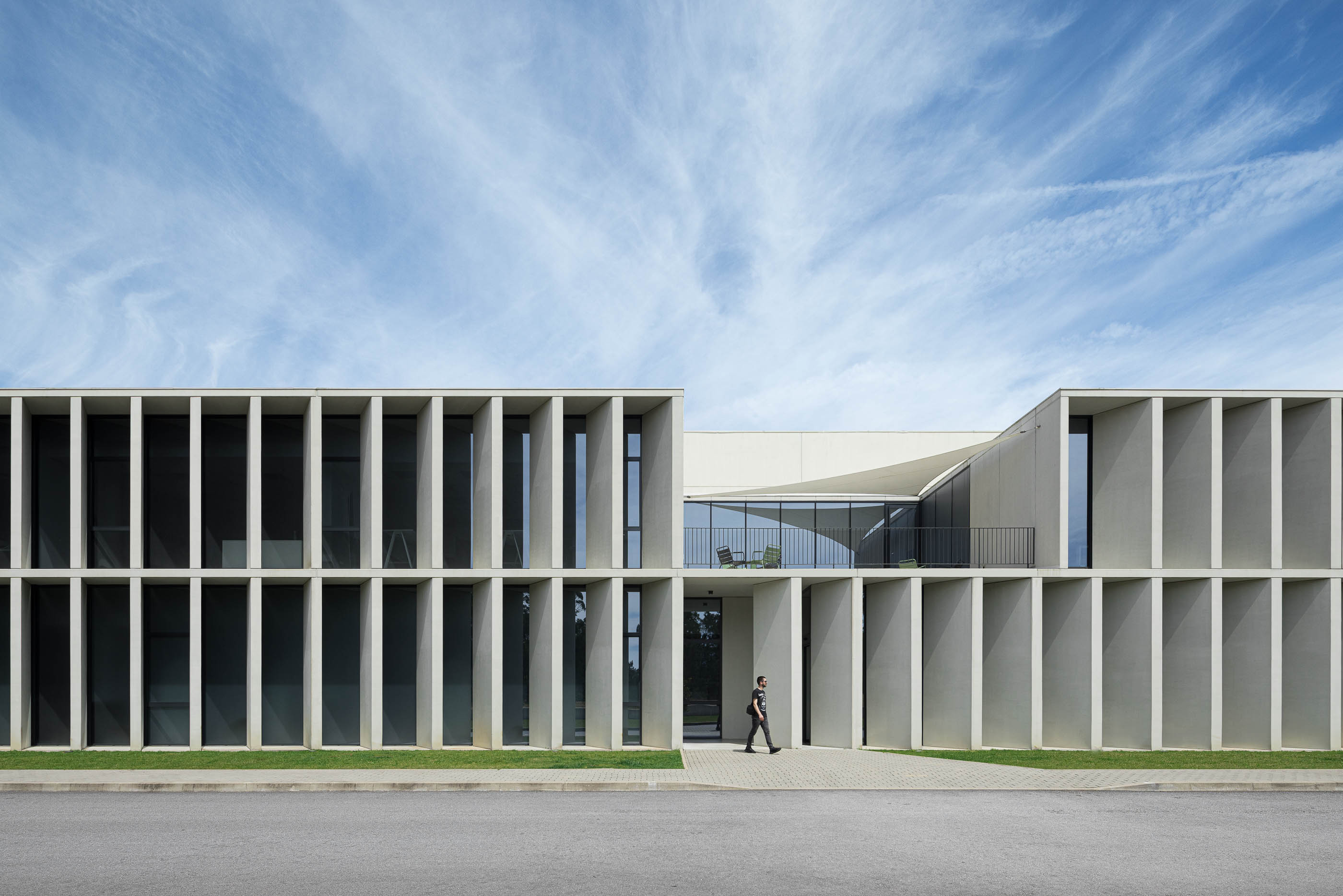 Exterior: Fachada principal do edifício com colunas de betão, janelas e entrada central. — BW II – Edifício Industrial em Viana do Castelo arquitetura Multiprojectus em Viana do Castelo