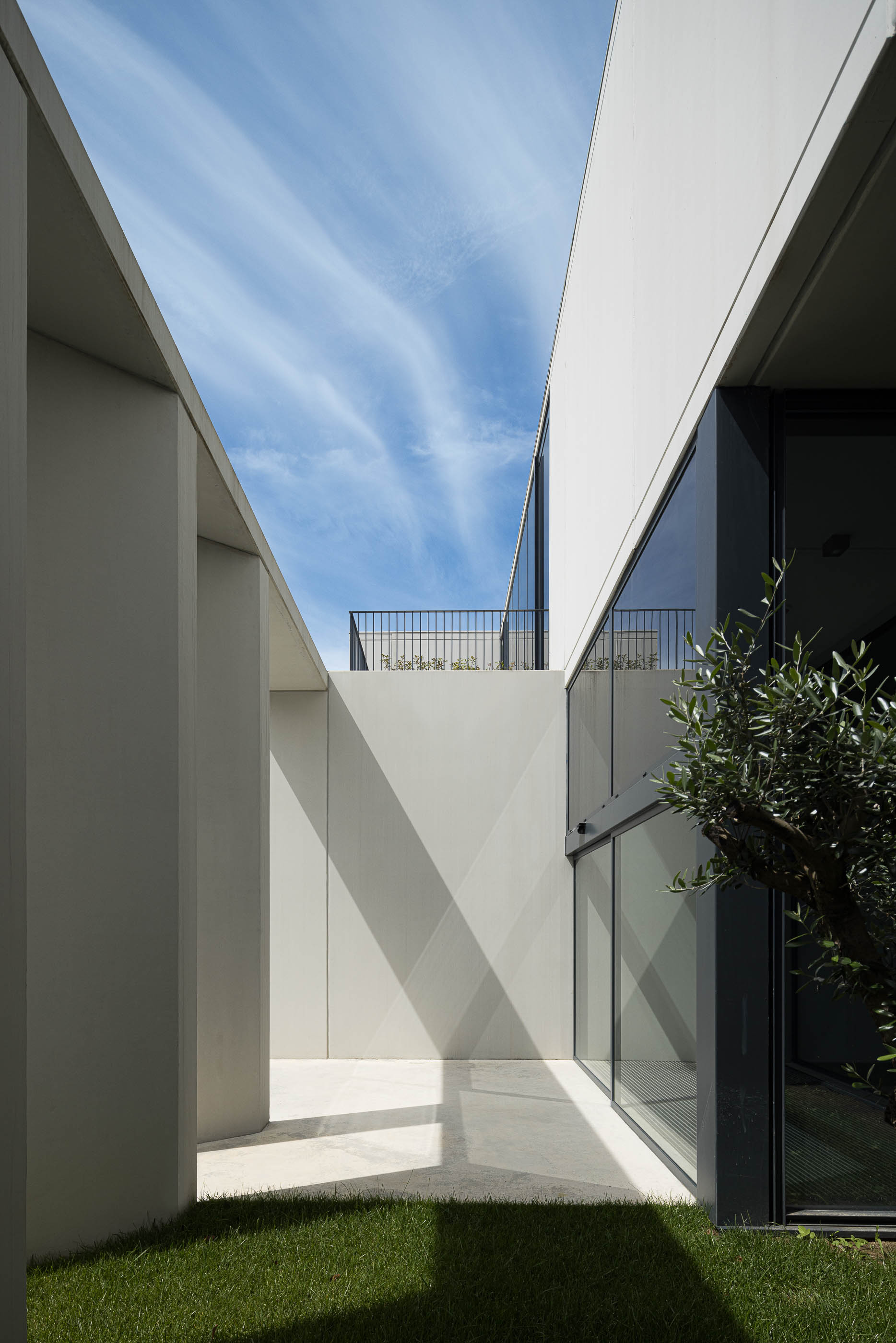 Exterior: Espaço exterior com relvado, paredes de betão e janelas envidraçadas. — BW II – Edifício Industrial em Viana do Castelo arquitetura Multiprojectus em Viana do Castelo