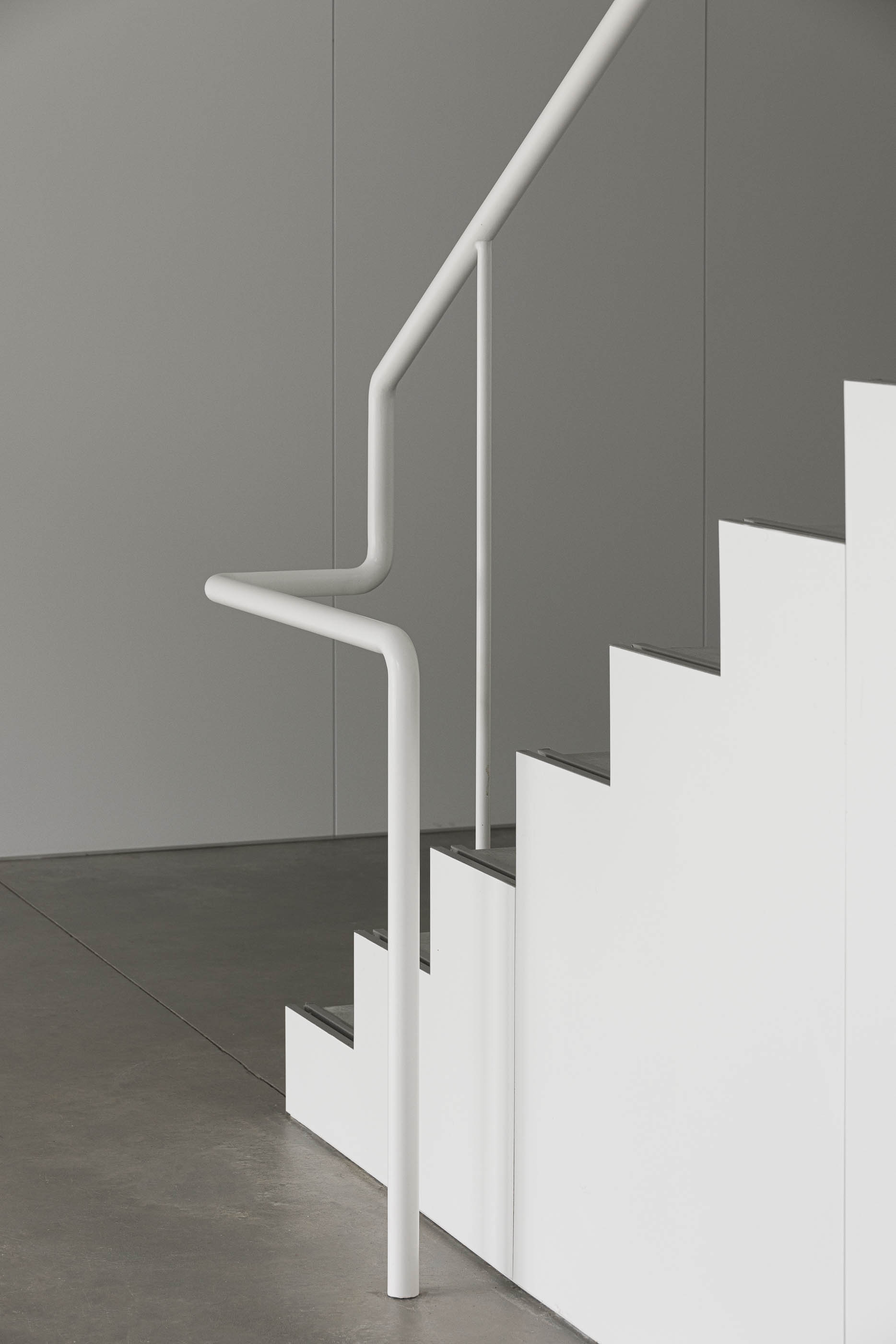 Escadaria: Pormenor do corrimão branco e degraus em betão da escadaria minimalista. — BW II – Edifício Industrial em Viana do Castelo arquitetura Multiprojectus em Viana do Castelo