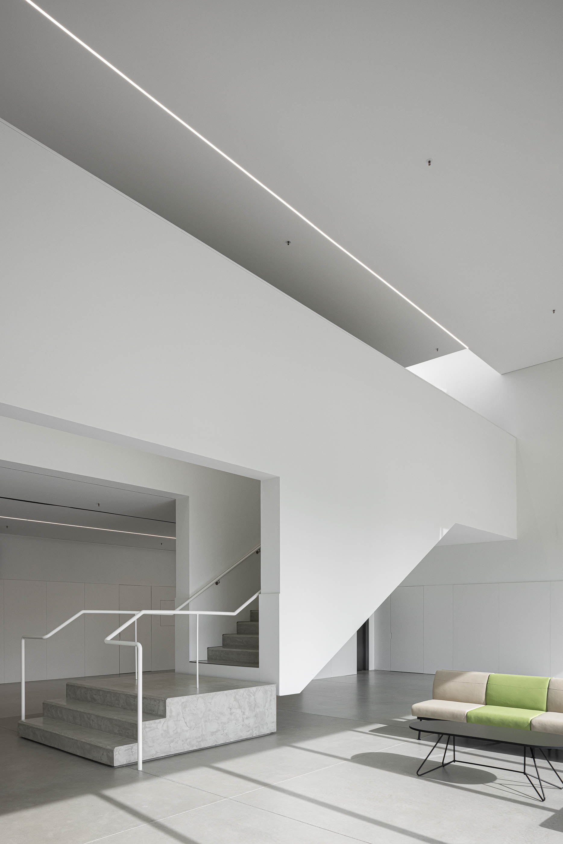Hall de entrada: Zona de estar com sofás, mesa de centro e vista para o exterior. — BW II – Edifício Industrial em Viana do Castelo arquitetura Multiprojectus em Viana do Castelo