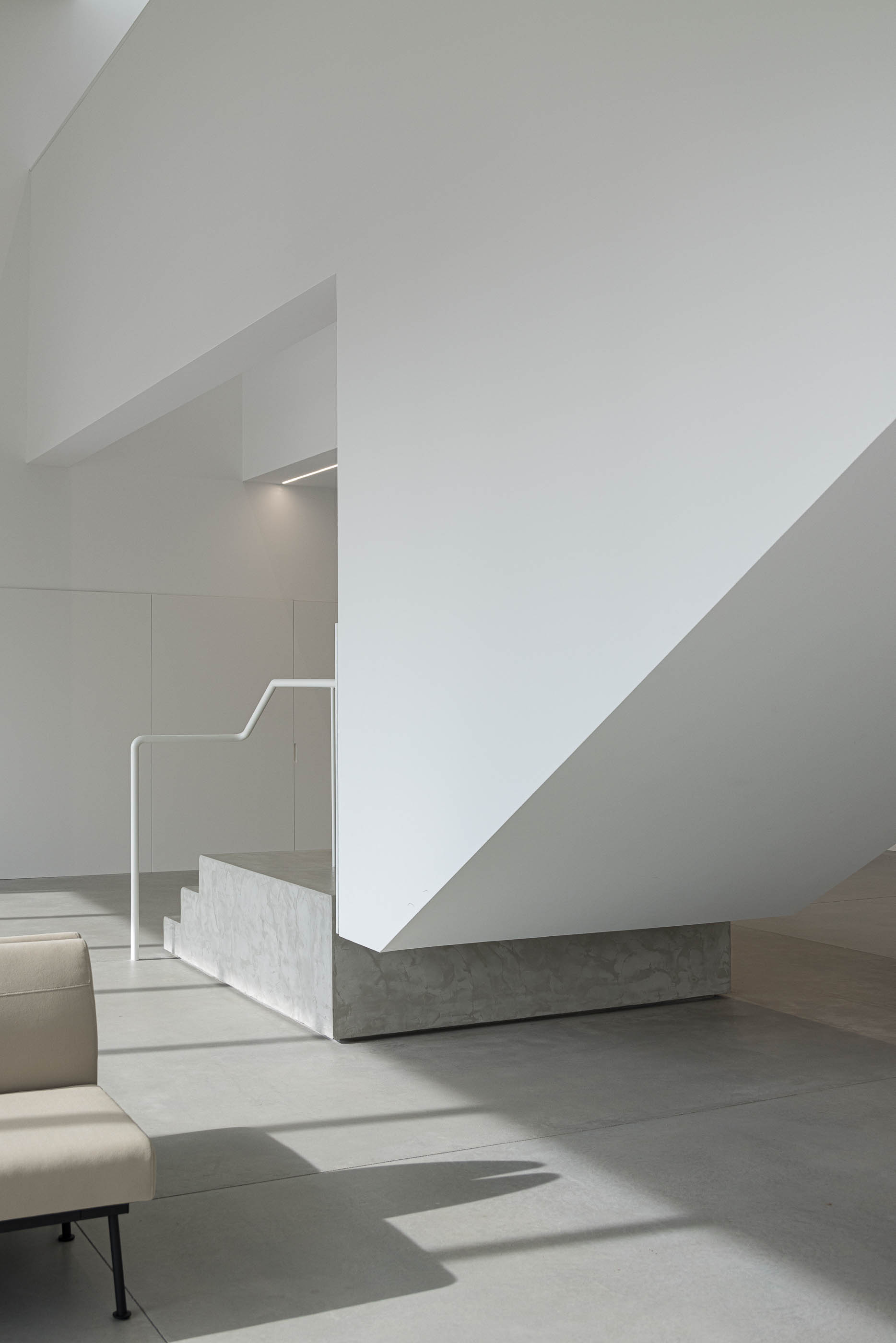 Entrada: Corredor com passadeira listrada, paredes brancas e vista para o hall de entrada. — BW II – Edifício Industrial em Viana do Castelo arquitetura Multiprojectus em Viana do Castelo