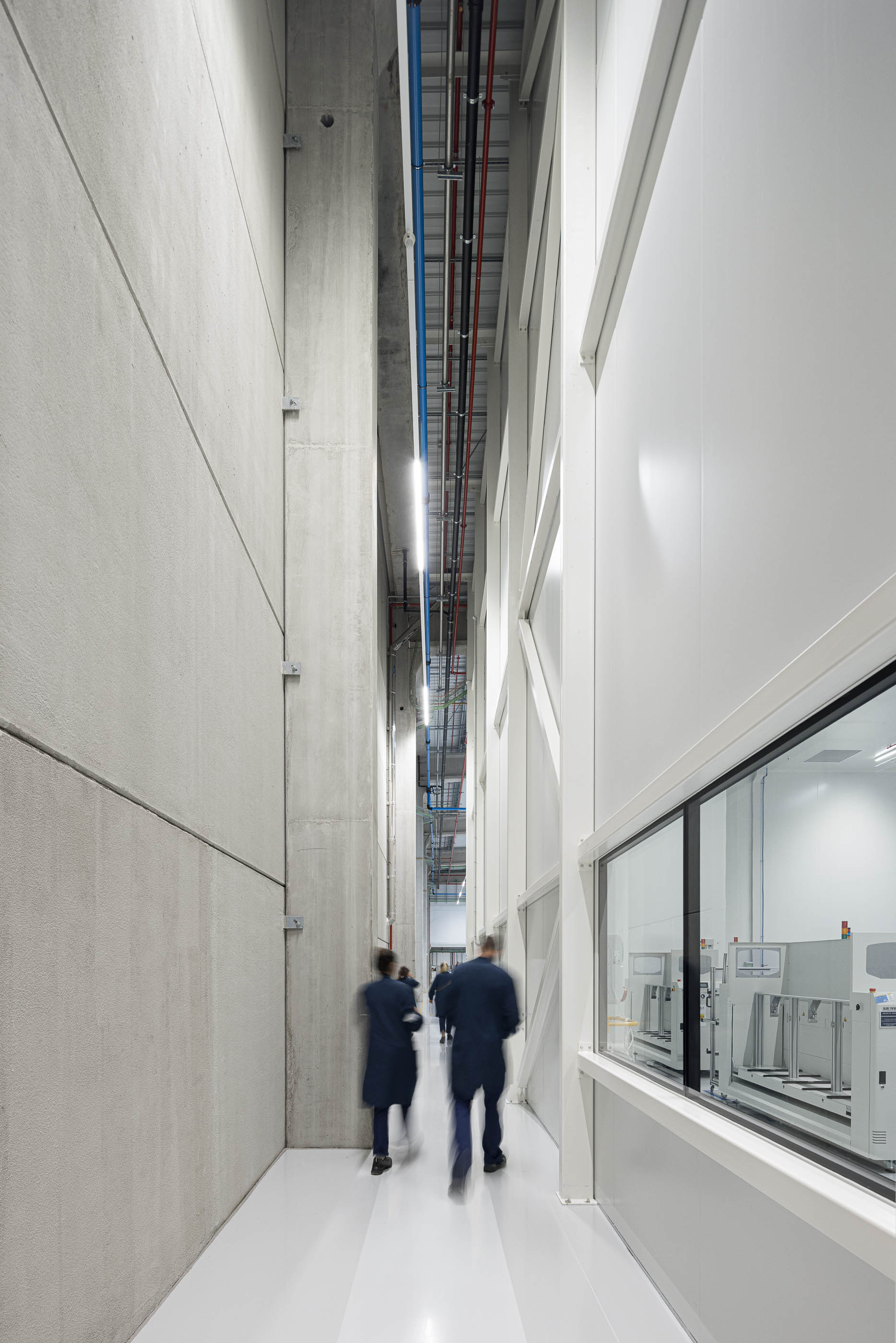 Fábrica: Espaço industrial com máquinas, tubagens expostas e pavimento demarcado a amarelo. — BW II – Edifício Industrial em Viana do Castelo arquitetura Multiprojectus em Viana do Castelo
