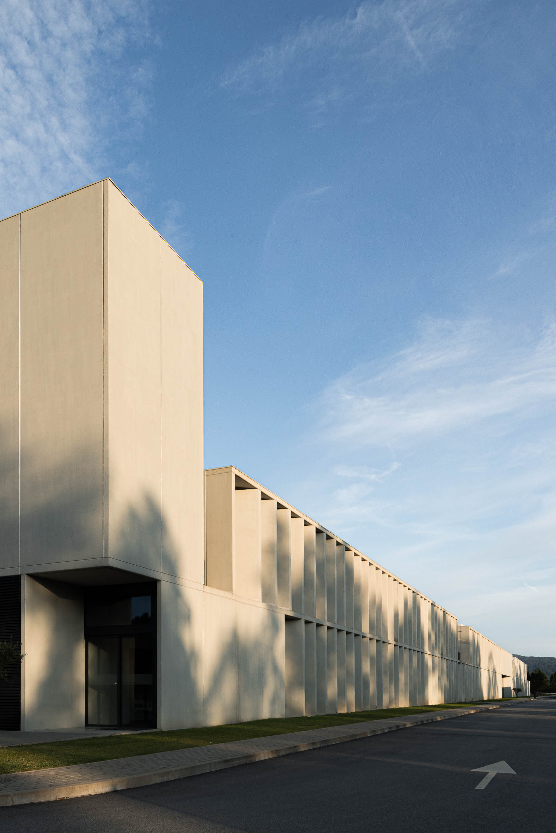 Exterior: Detalhe da fachada do edifício com colunas de betão e vegetação. — BW II – Edifício Industrial em Viana do Castelo arquitetura Multiprojectus em Viana do Castelo