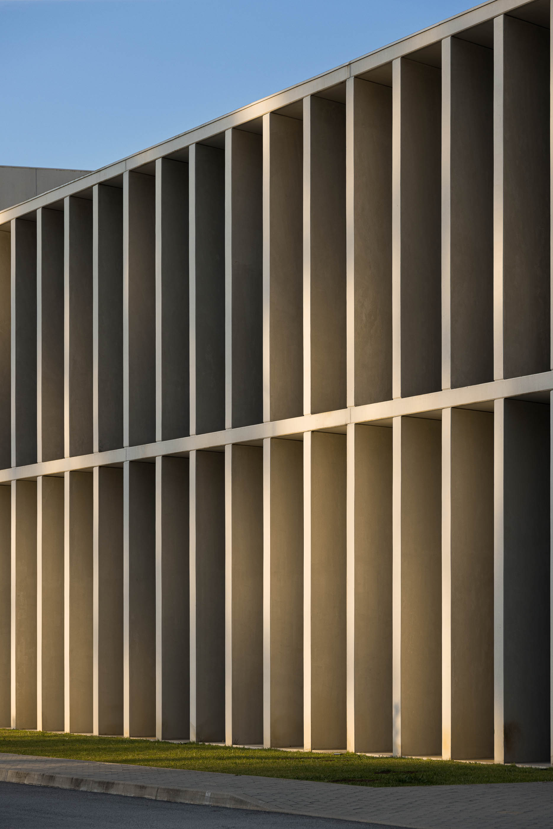 Exterior: Edifício industrial com colunas de betão e paisagem natural ao fundo. — BW II – Edifício Industrial em Viana do Castelo arquitetura Multiprojectus em Viana do Castelo