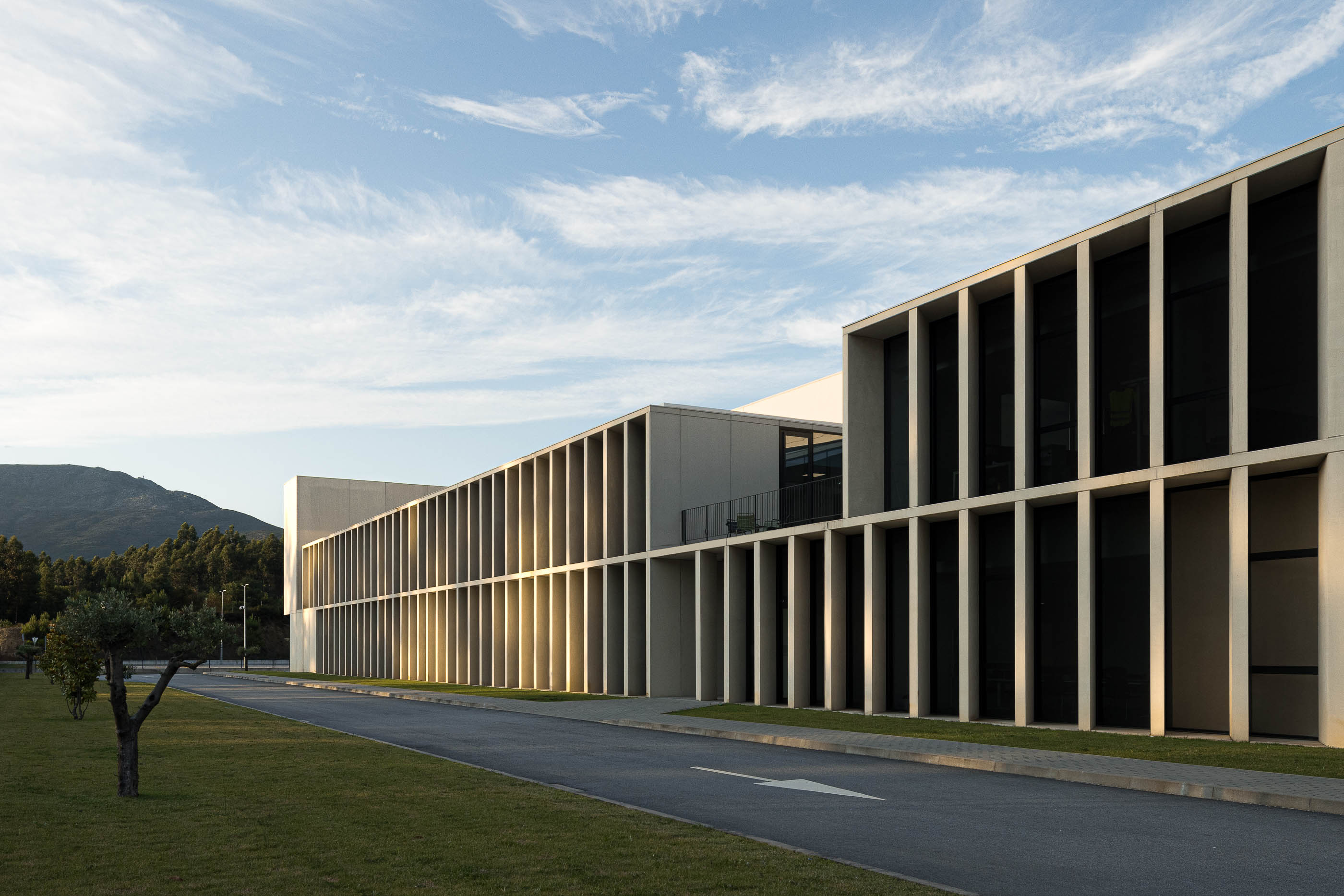 Escadaria: Detalhe das escadas em betão com corrimão branco e luz natural. — BW II – Edifício Industrial em Viana do Castelo arquitetura Multiprojectus em Viana do Castelo