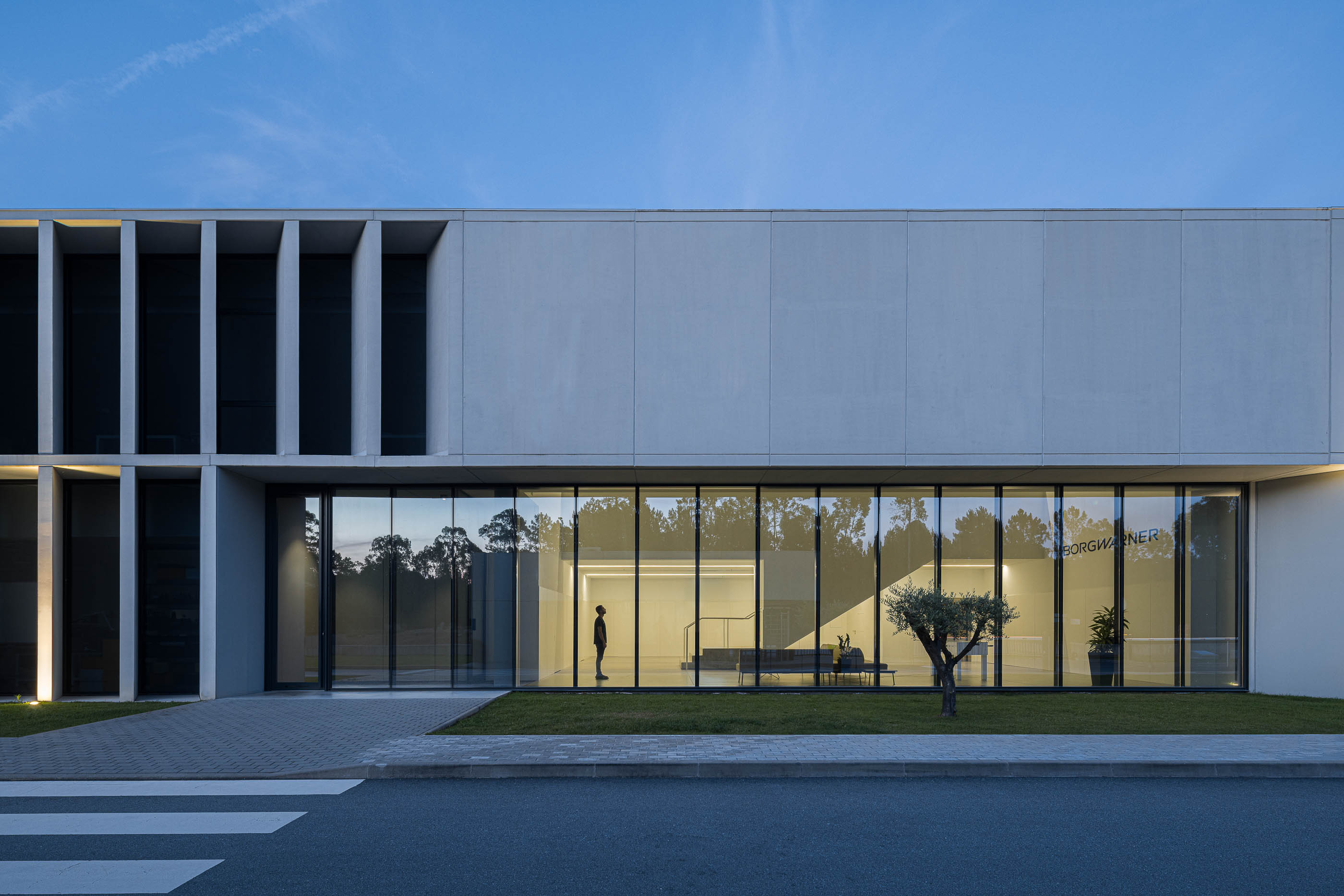 Hall de entrada: Vista através das janelas do hall de entrada com escadas e zona de estar. — BW II – Edifício Industrial em Viana do Castelo arquitetura Multiprojectus em Viana do Castelo