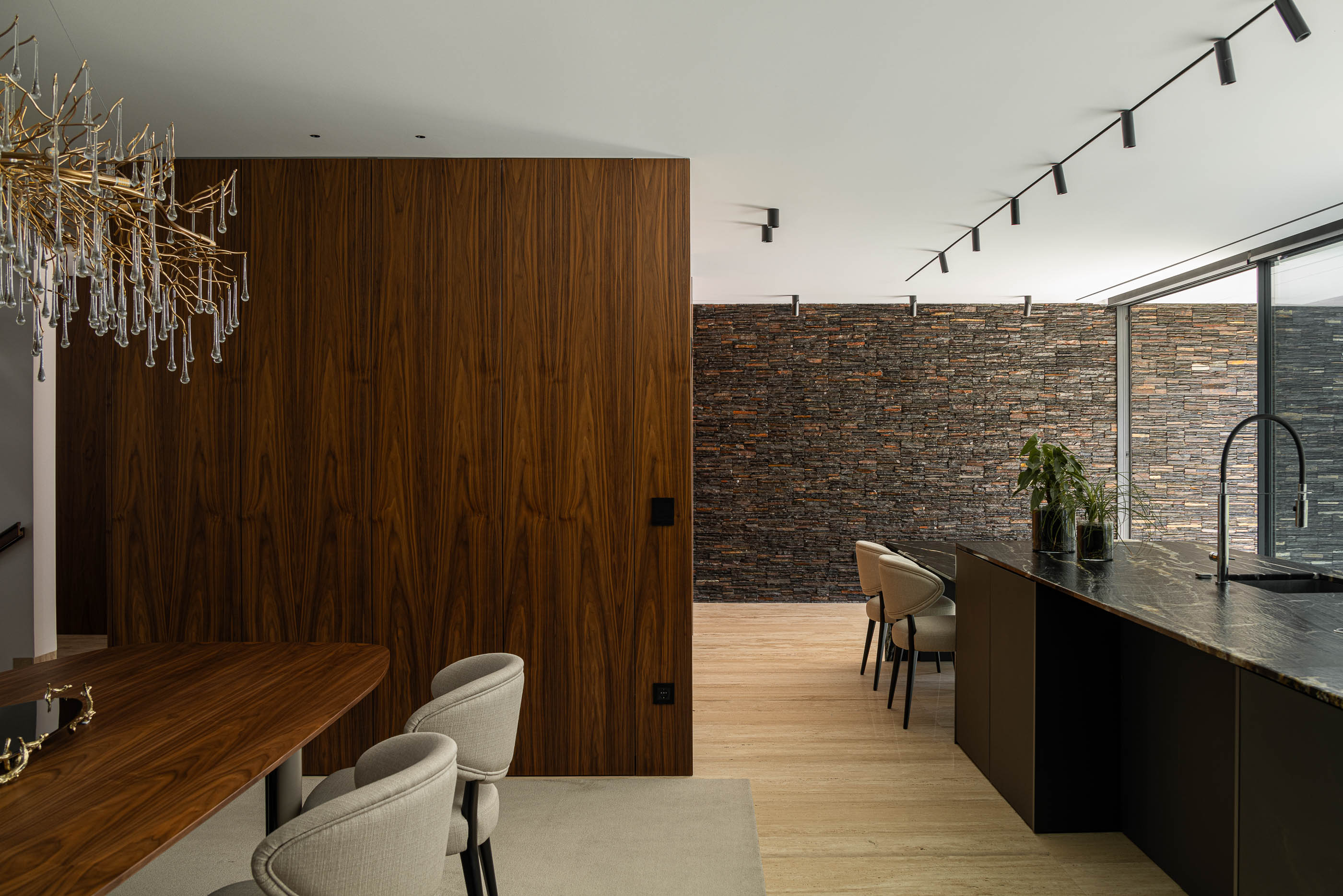 Sala de estar/jantar: Espaço amplo com mesa de jantar, ilha de cozinha e parede em madeira. — Casa SA arquitetura Sandro Ferreira Arquitectura em Braga
