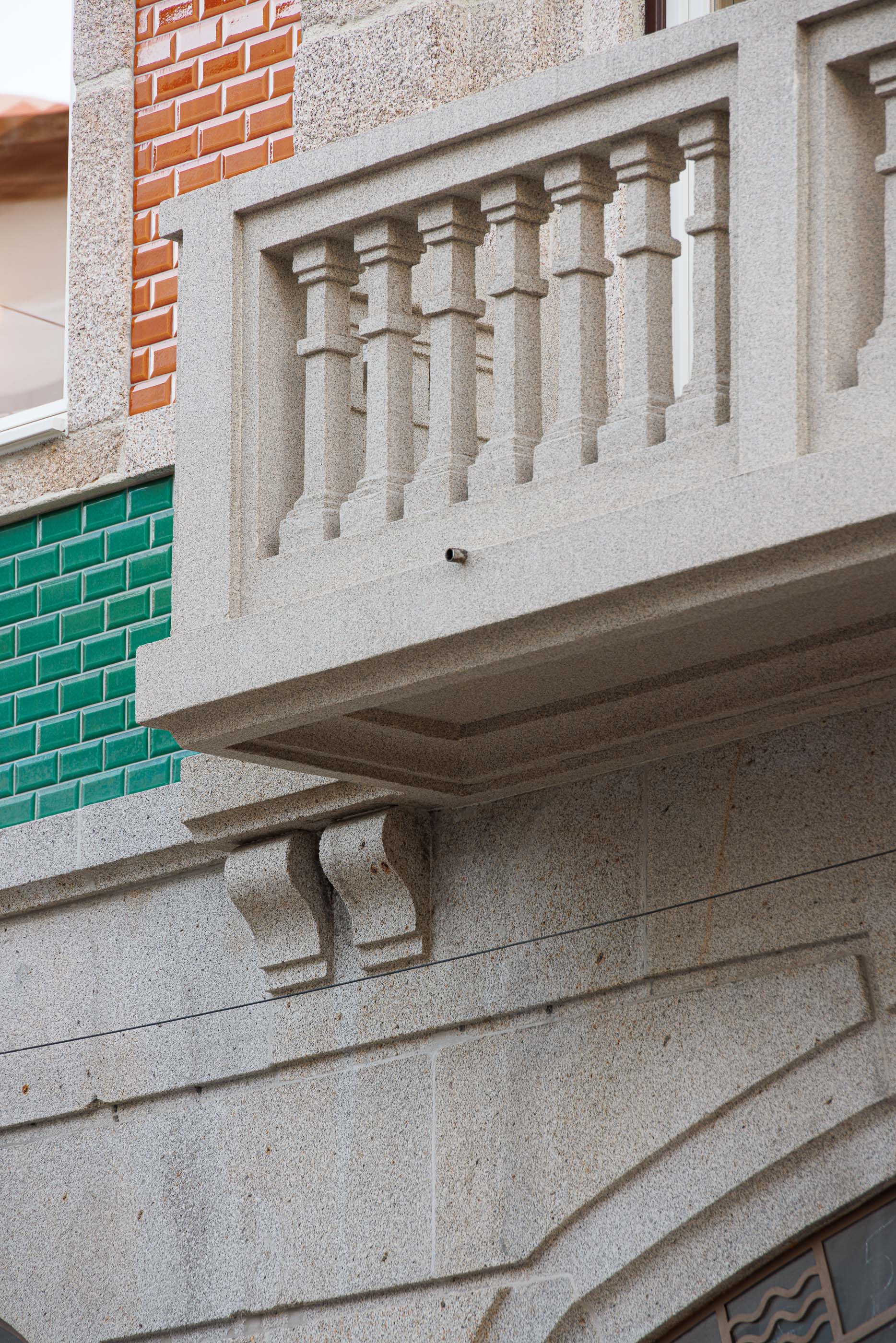 Varanda: Detalhe da varanda em granito com balaustrada clássica e azulejos verdes. — Apartamentos Vitória arquitetura Floret Arquitectura em Viseu