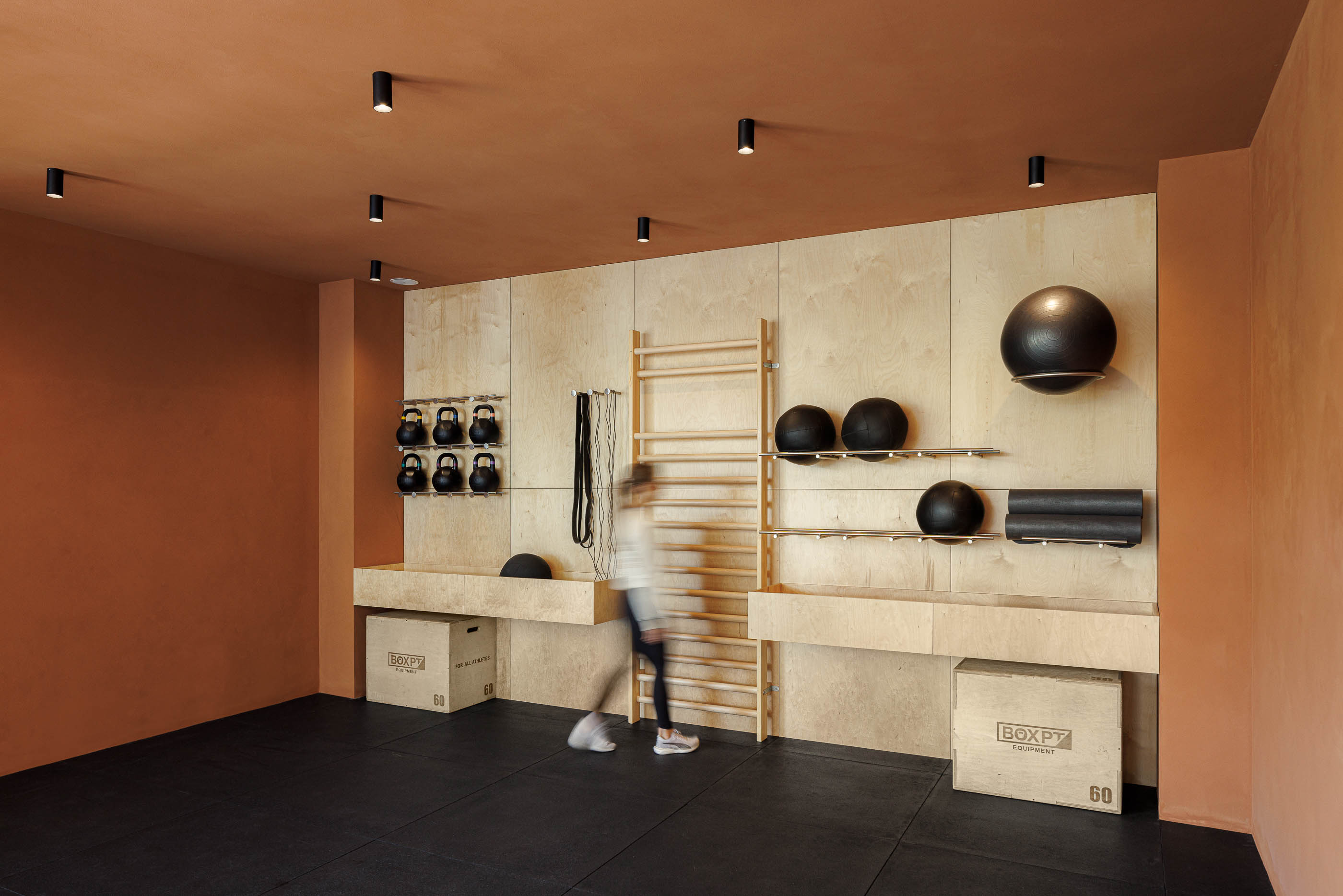 Detalhe: Parede em contraplacado com bolas de ginástica e tapetes de yoga. — Level Private Gym arquitetura stu.dere em Penafiel