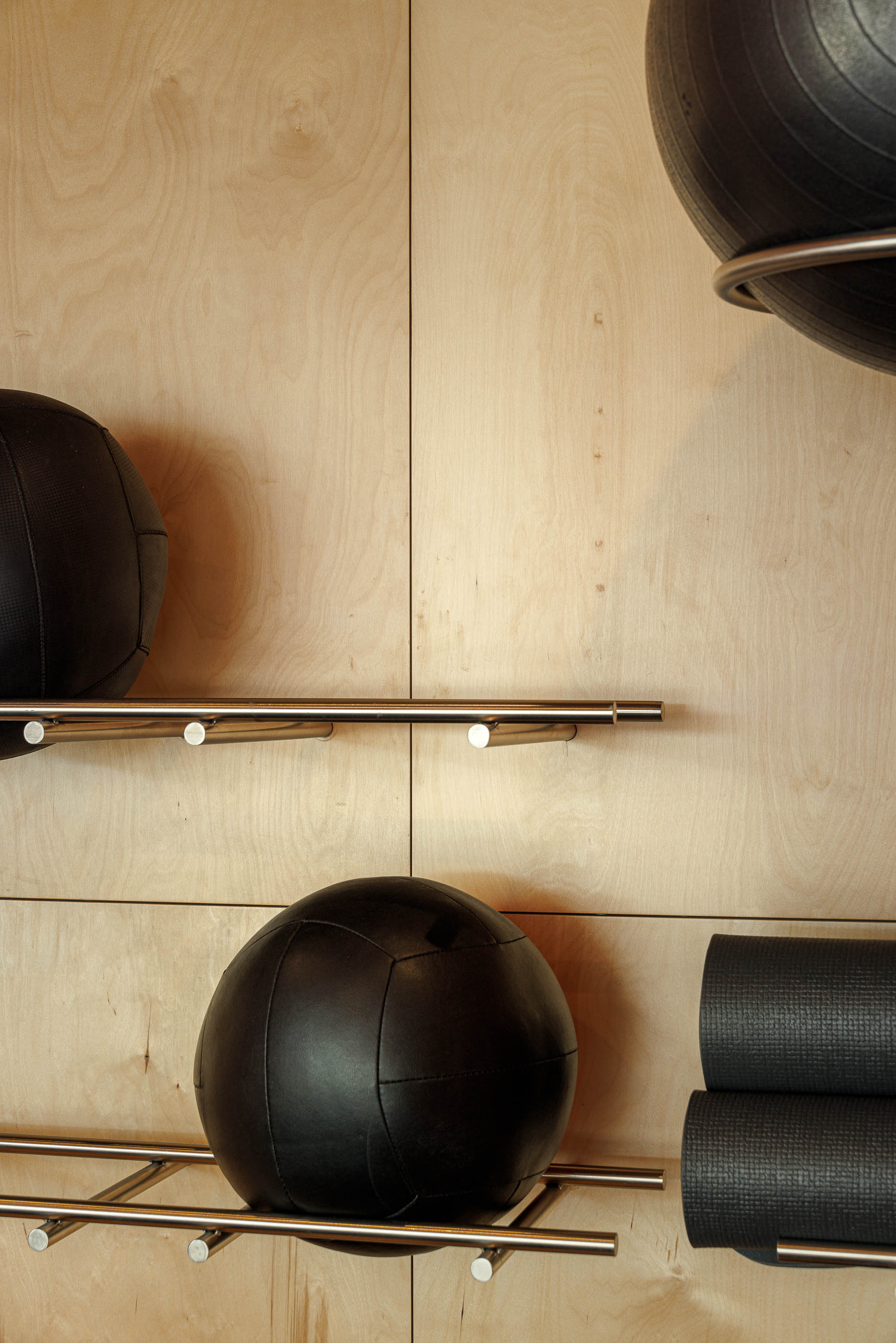 Sala de treino funcional: Mulher a treinar no chão, parede em contraplacado e cor de tijolo. — Level Private Gym arquitetura stu.dere em Penafiel