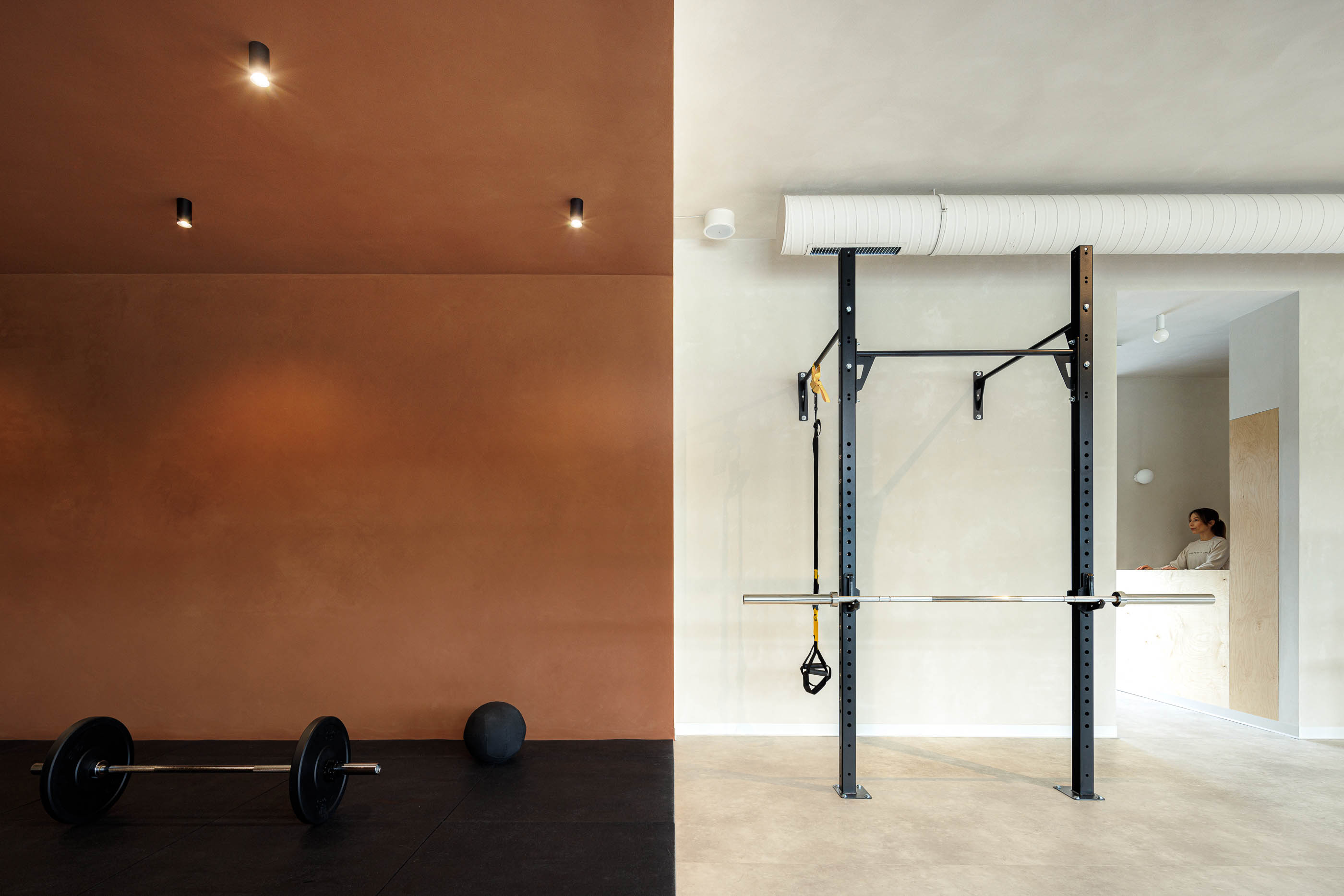 Vestiário: Cabides, cacifos em contraplacado, banco em madeira, azulejos brancos com juntas cor de laranja. — Level Private Gym arquitetura stu.dere em Penafiel