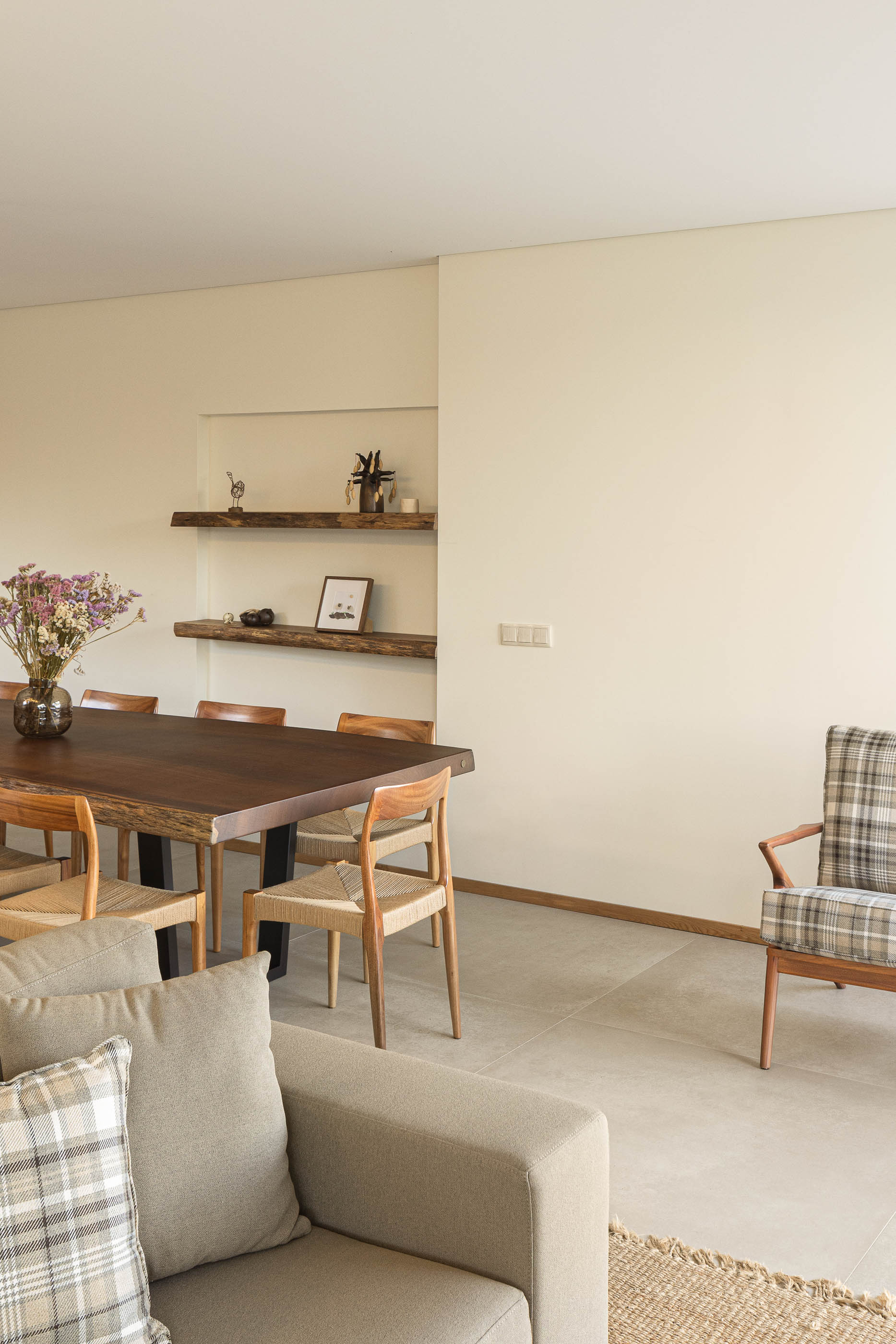 Sala de estar/jantar: Detalhe da mesa de jantar em madeira, cadeiras e estantes em madeira rústica. — Casa da Levada arquitetura Tsou Arquitectos em Penafiel