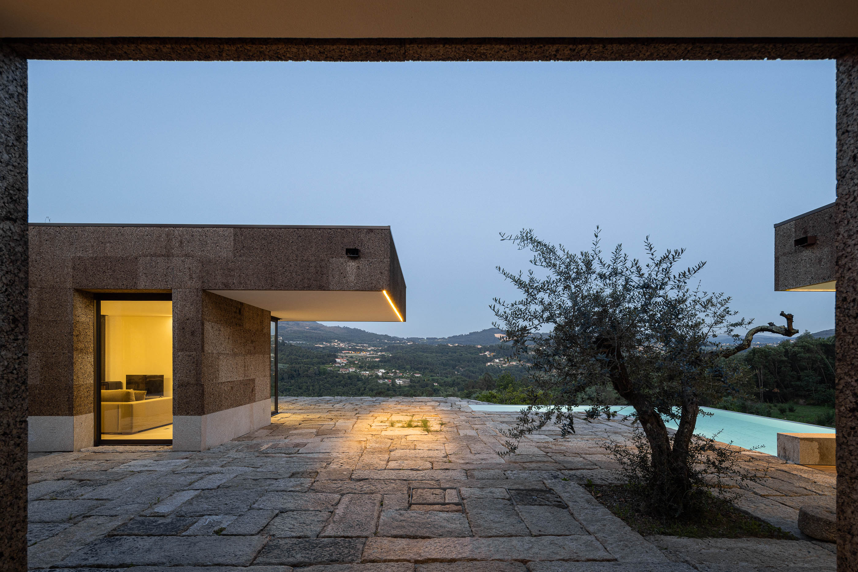 Exterior: Pátio em pedra com oliveira e vista para a paisagem. — Casa da Levada arquitetura Tsou Arquitectos em Penafiel