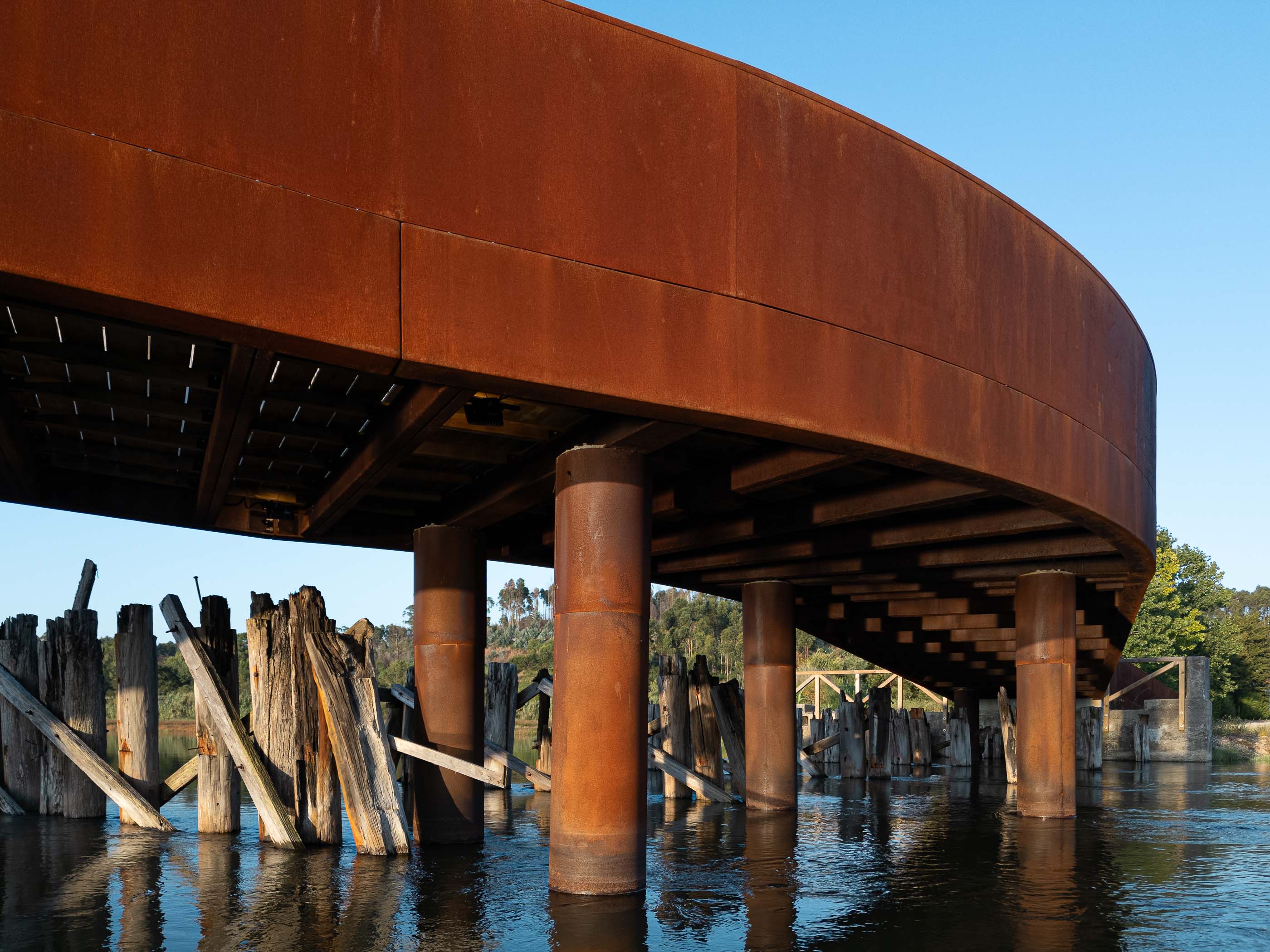 Ponte: Vista aérea da ponte, com passadiço em madeira e barco moliceiro atracado. — Requalificação da antiga Ponte da Fareja arquitetura Rómulo Neto Arquitectos em Aveiro